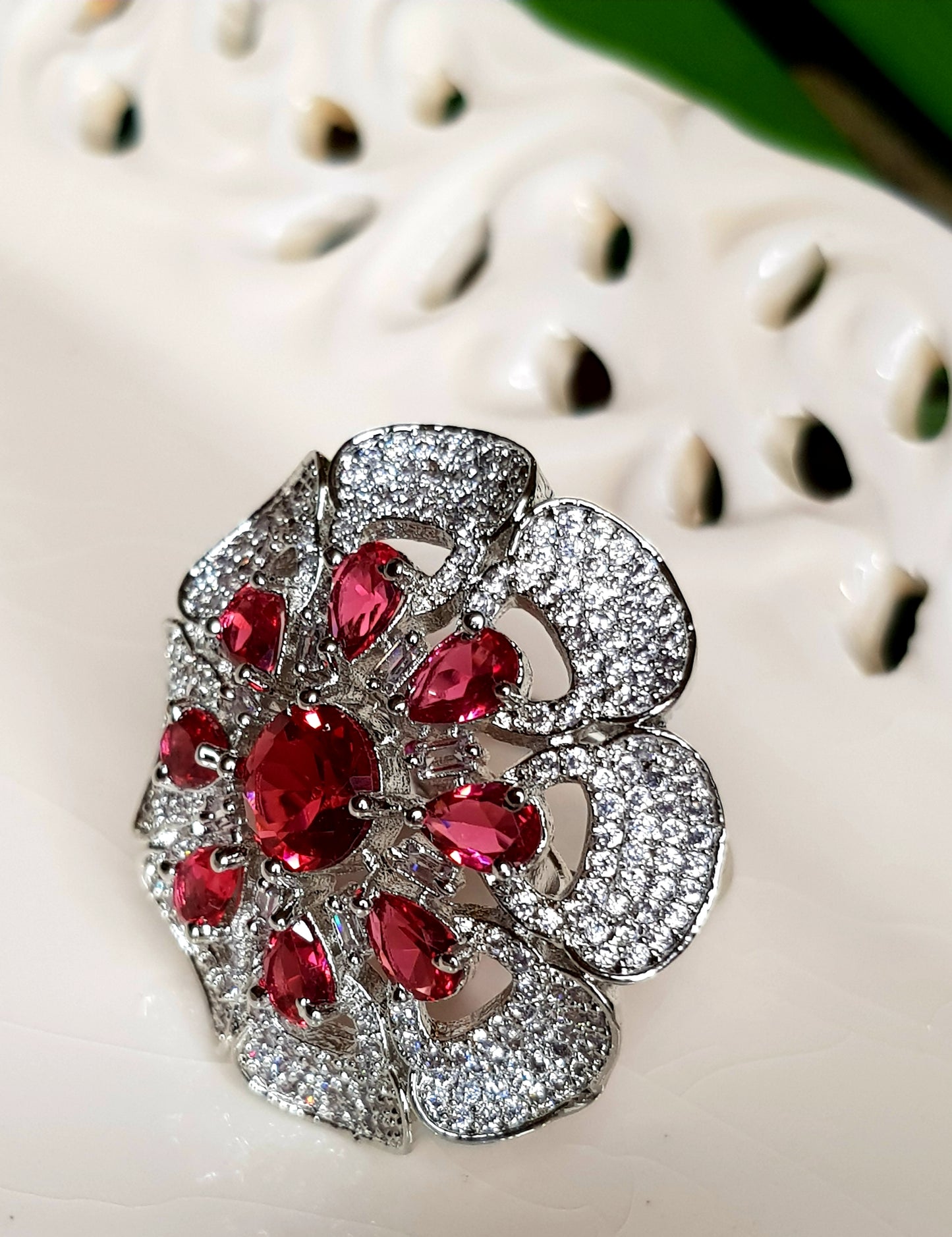 Antique finish ring, flower motif with ruby red stones and CZ detailing