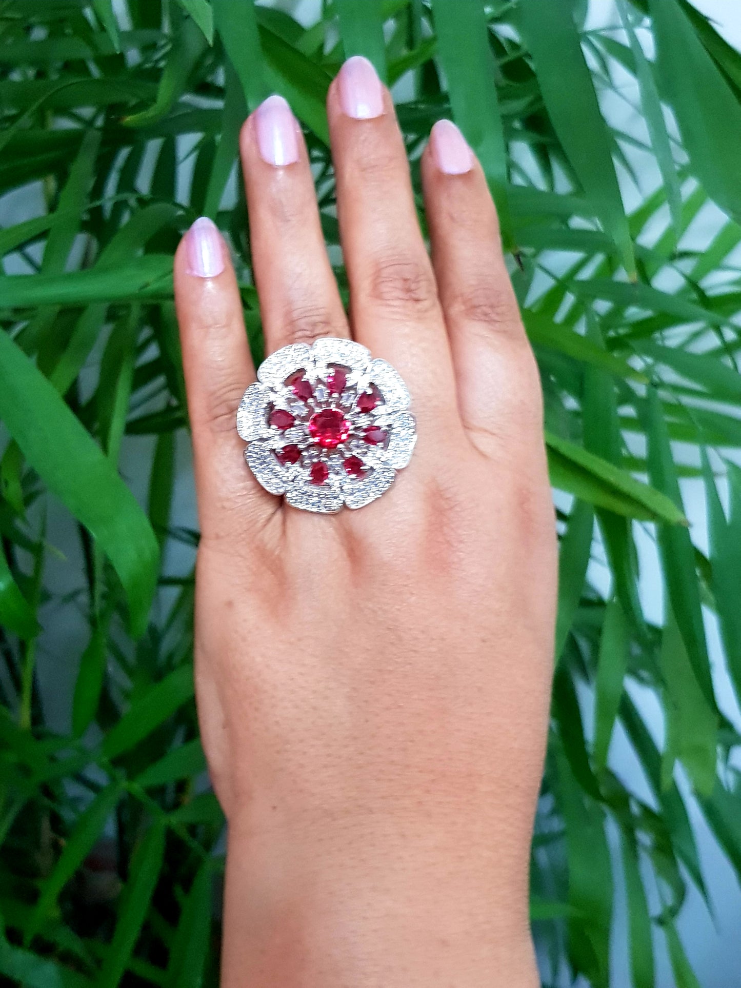 Antique finish ring, flower motif with ruby red stones and CZ detailing