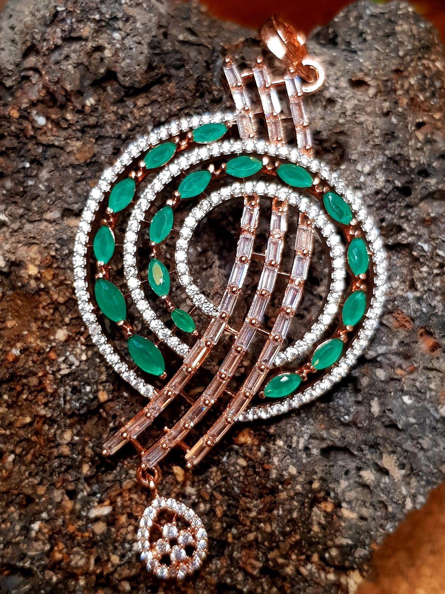 Cosmic spiral pendant set studded with emerald green and champagne stones