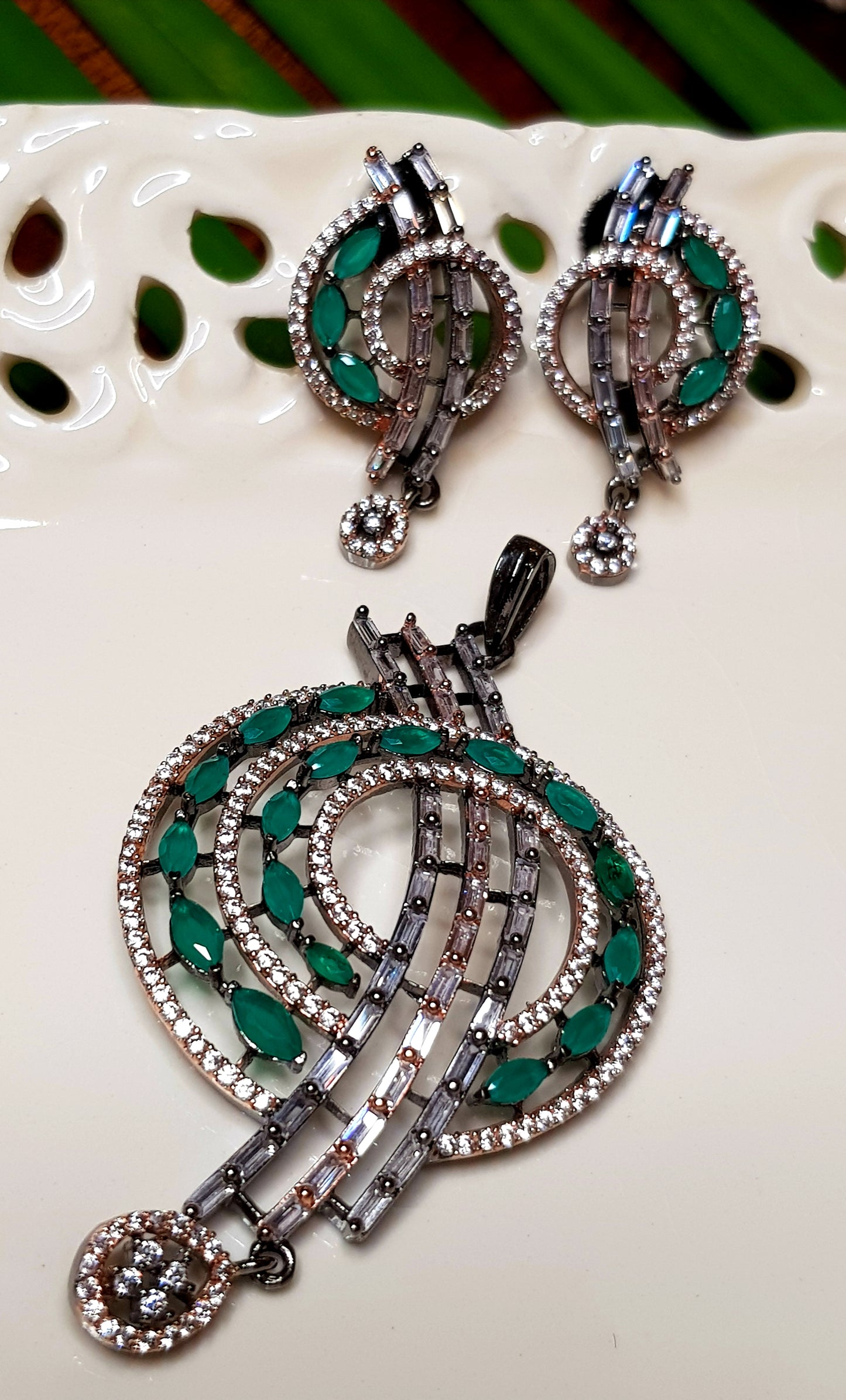 Cosmic spiral pendant set studded with emerald green and champagne stones