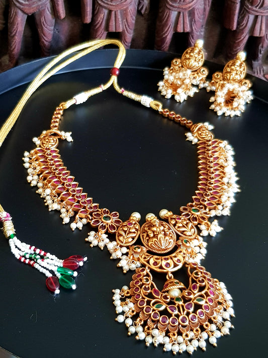 Temple jewelry set, necklace with Goddess Lakshmi motif and red stones detailing, matching jhumkas (earrings)