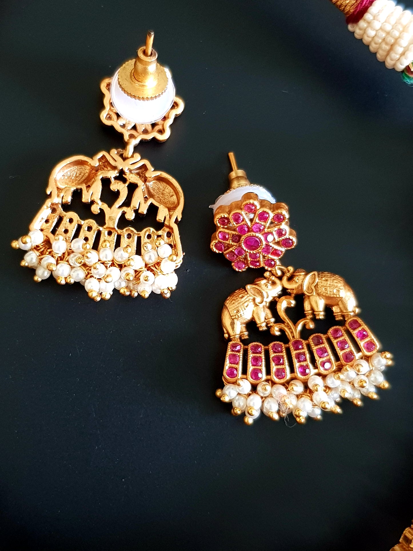 A gorgeous kemp stone set with marching elephants, red stone inlay with pearl hangings