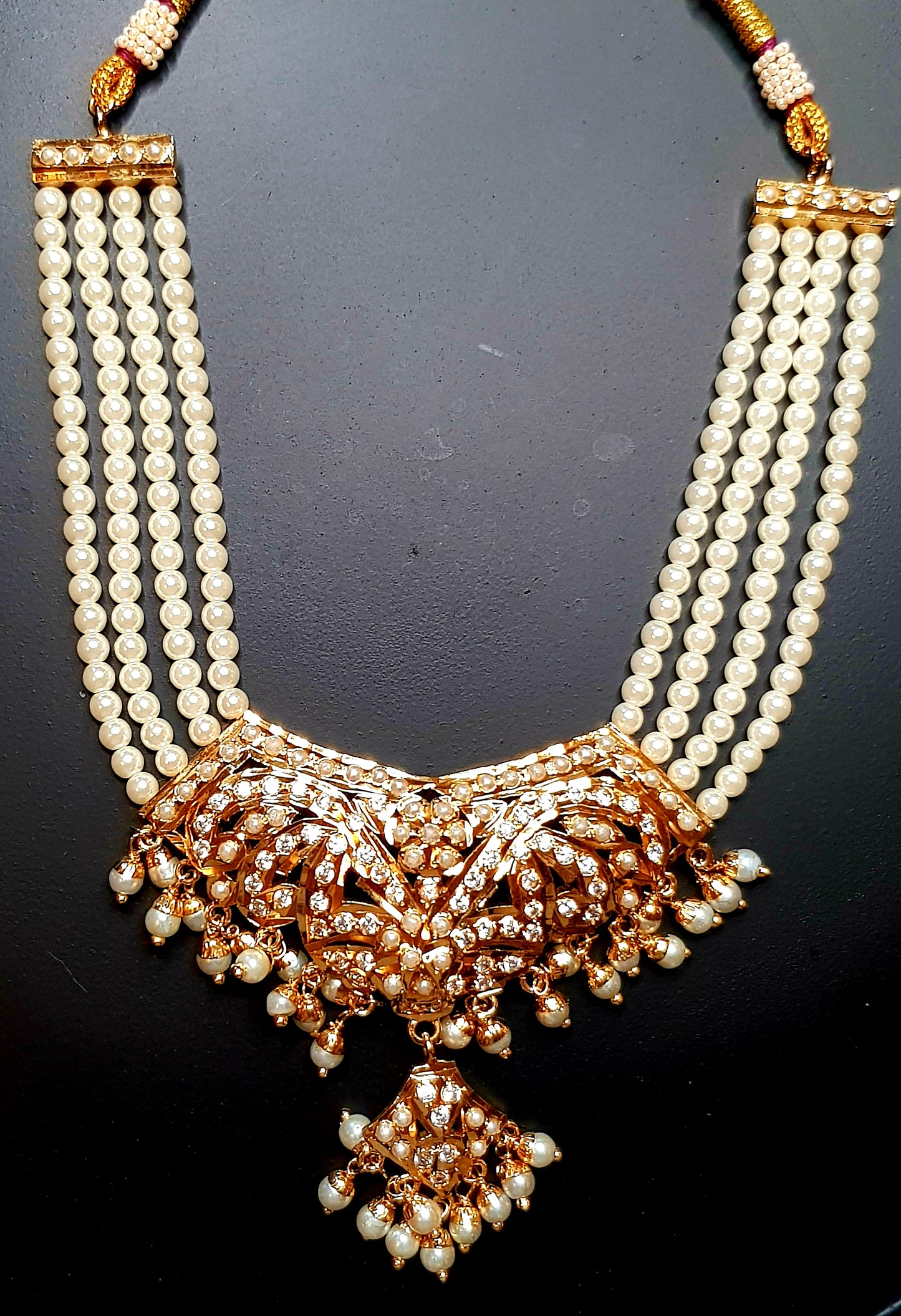 Jadau set in pearls with a hanging pendant, triple pearl strands, in choker style and matching  earrings