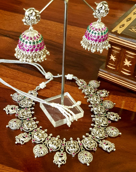 Silver finish temple jewelry set, necklace with Lakshmi motif, green-red stones inlay, matching jhumkas (earrings)