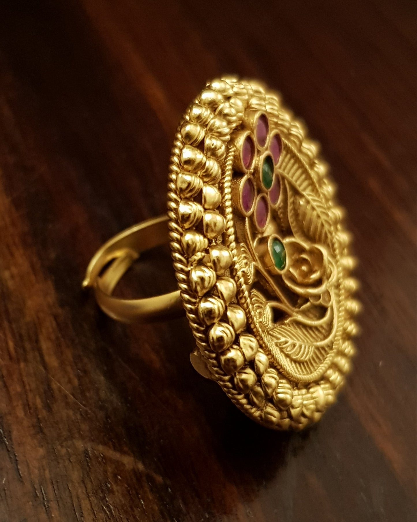 Temple jewelry ring in gold finish with flower engraving.