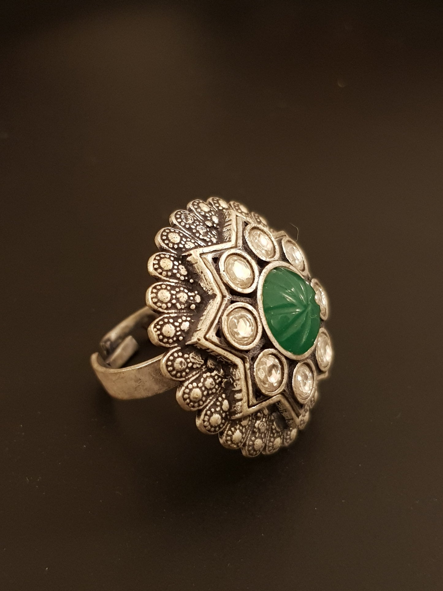 Silver finish ring with emerald stone and kundan detailing