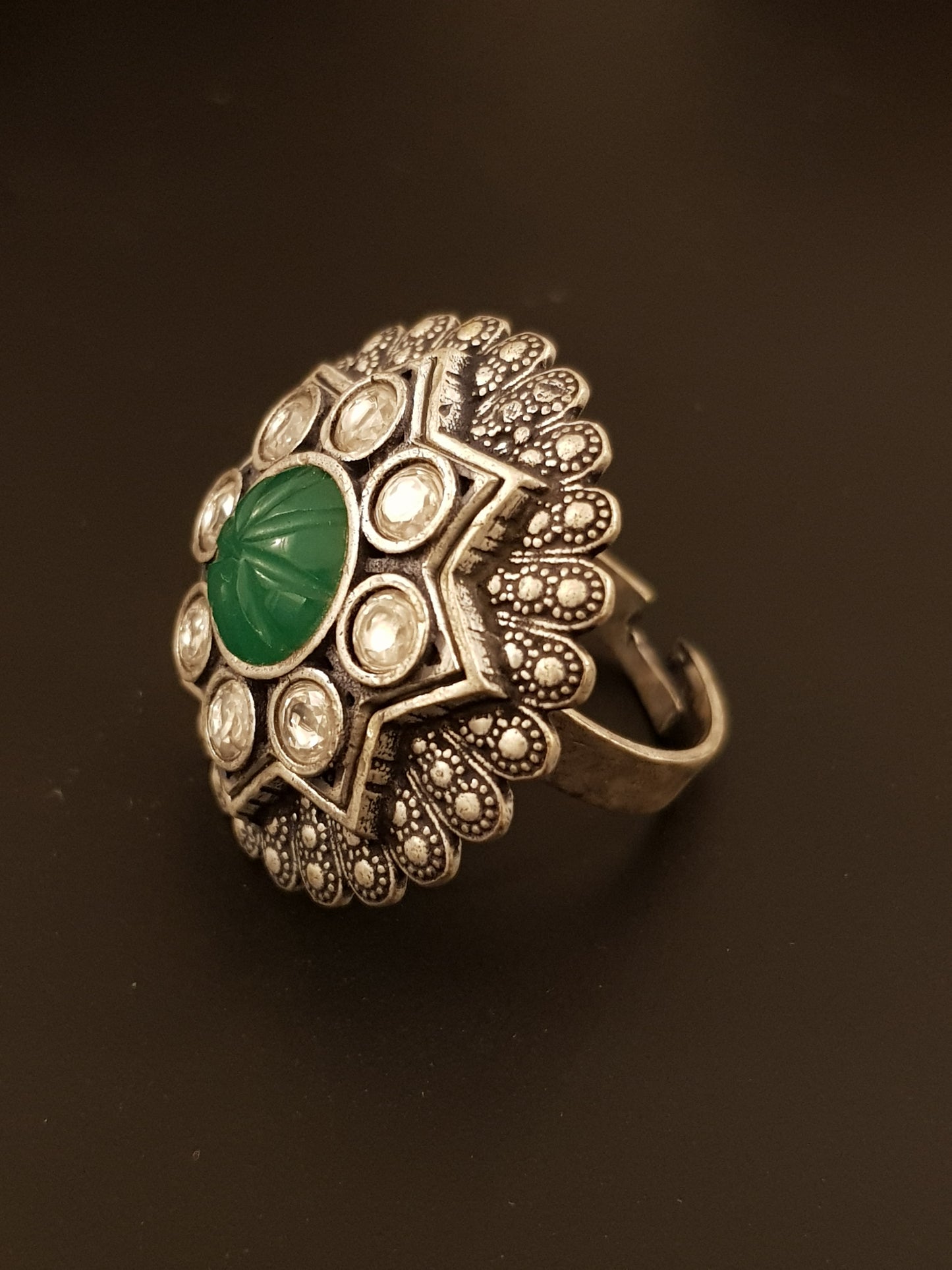 Silver finish ring with emerald stone and kundan detailing