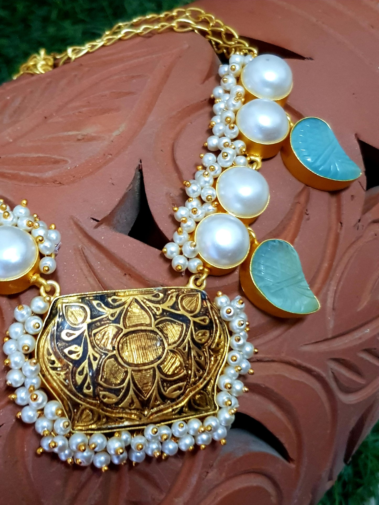 Neacklace in gold finish with black meenakari pendant and paisley design aqua blue stone