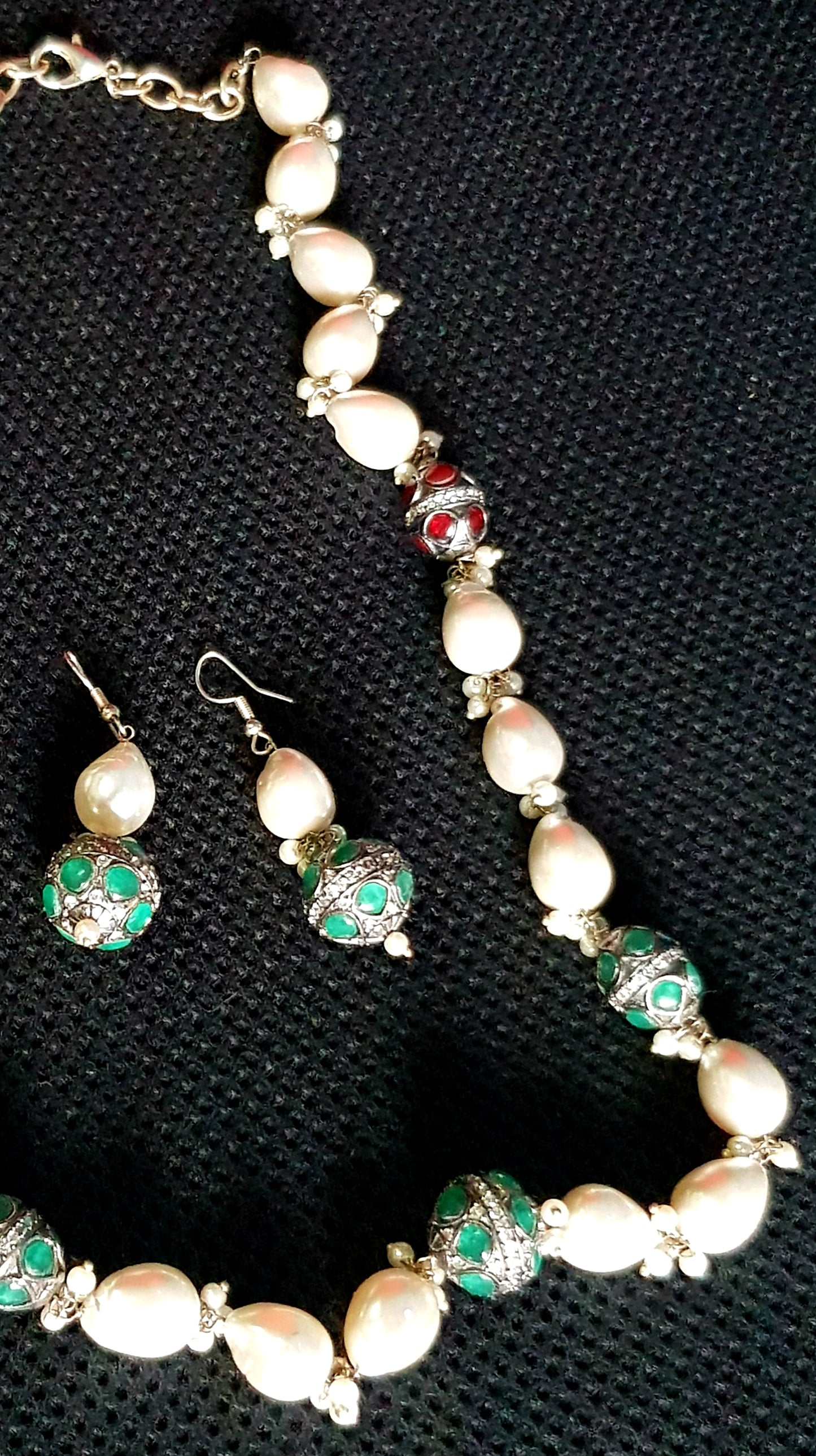 Set with white baroque pearl and red and green stone metal beads with detailing, matching earrings