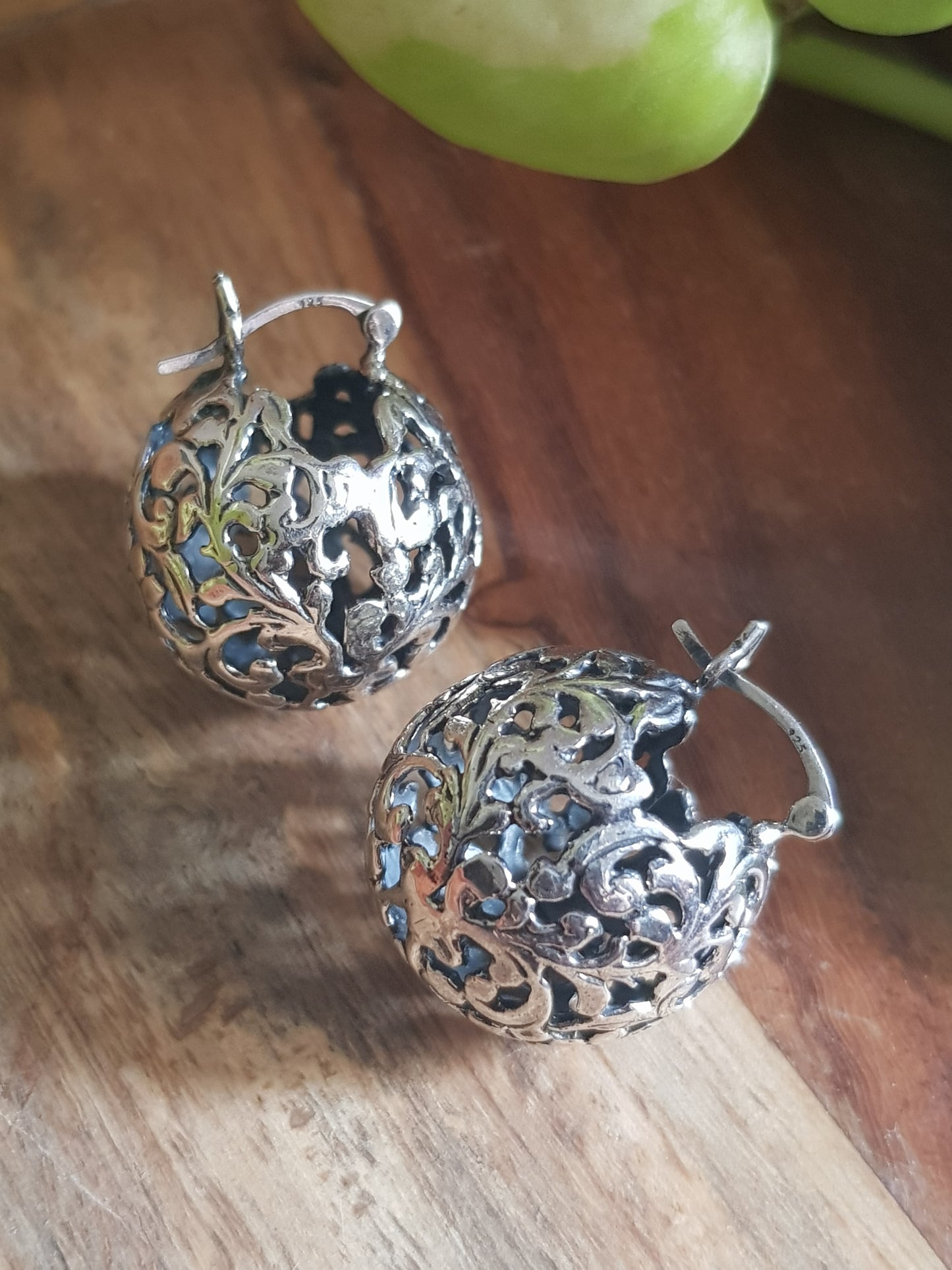 Silver earrings, globe shaped with intricate work, clasp lock system