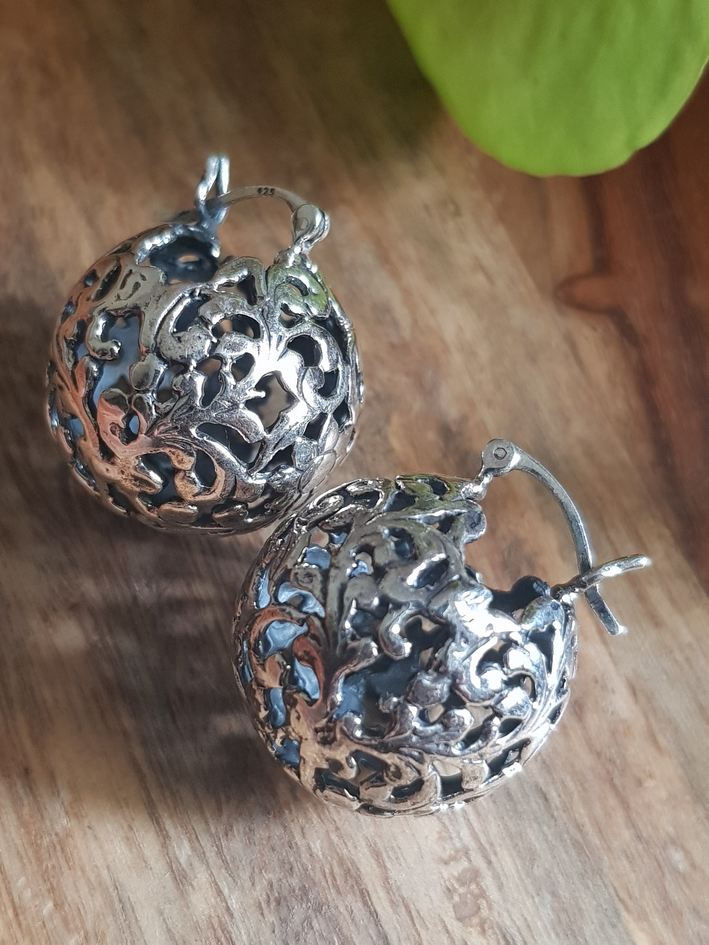 Silver earrings, globe shaped with intricate work, clasp lock system