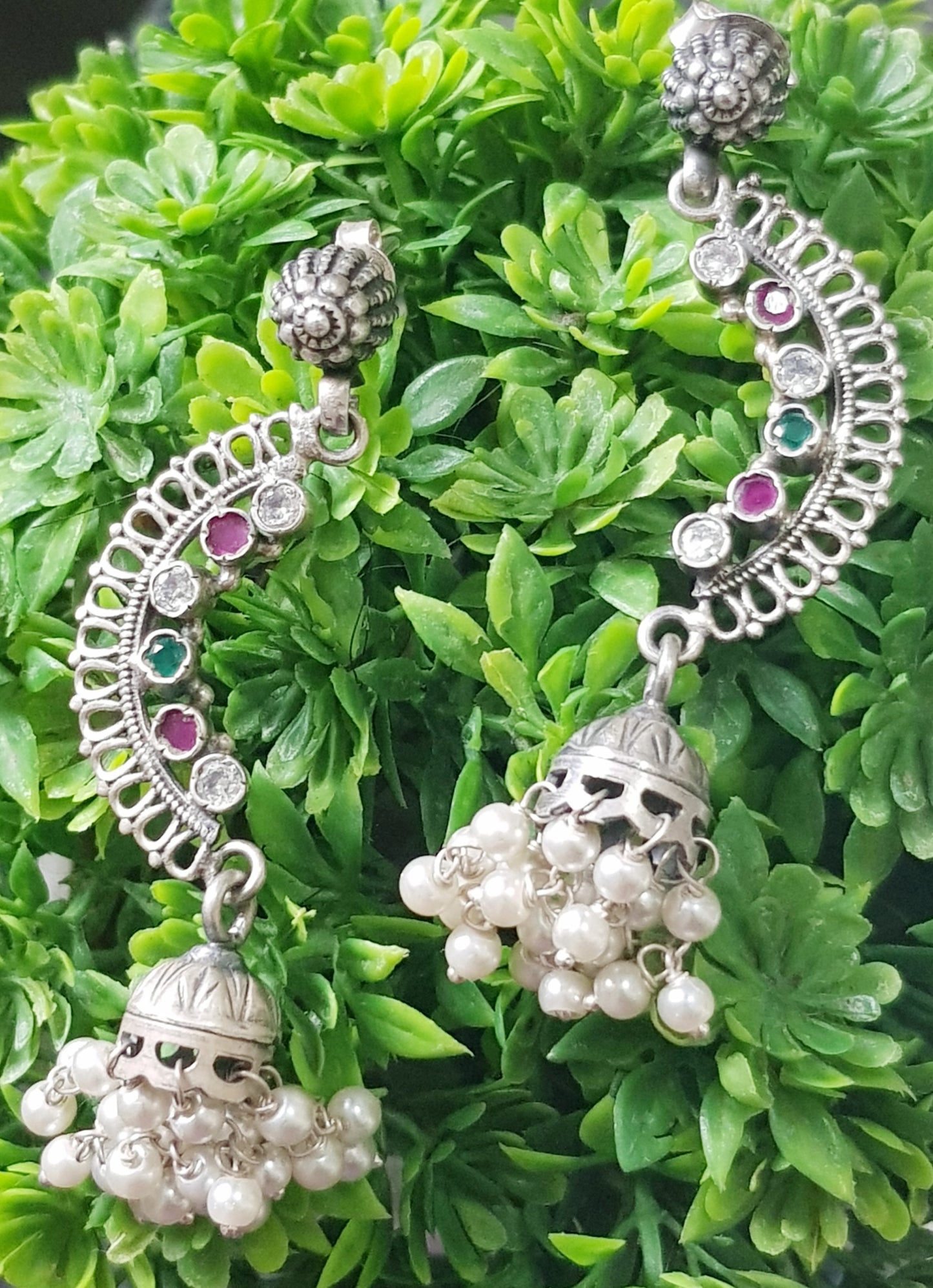 Silver earrings, C-shaped with stones detailing and small jhumka at the end with pearl beads