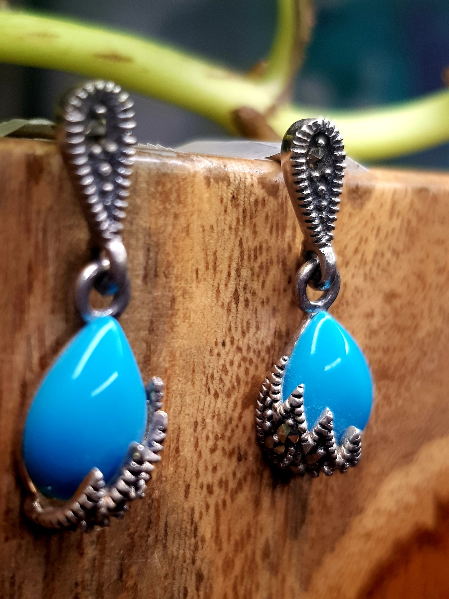 Silver earrings, teardrop shaped turquoise stone hanging under silver stud, marcasite detailing