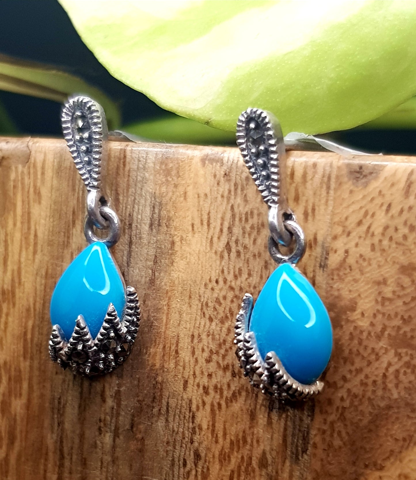 Silver earrings, teardrop shaped turquoise stone hanging under silver stud, marcasite detailing