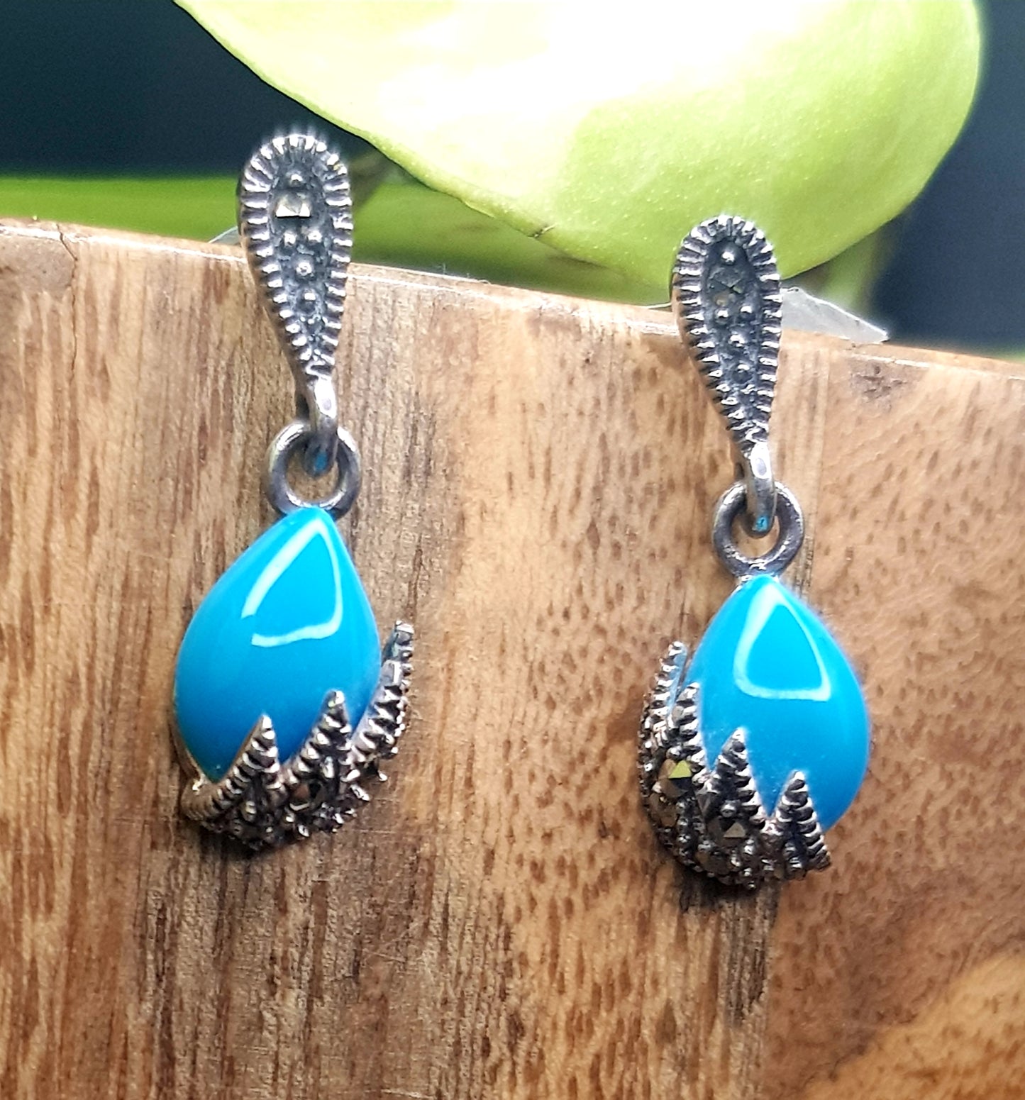 Silver earrings, teardrop shaped turquoise stone hanging under silver stud, marcasite detailing