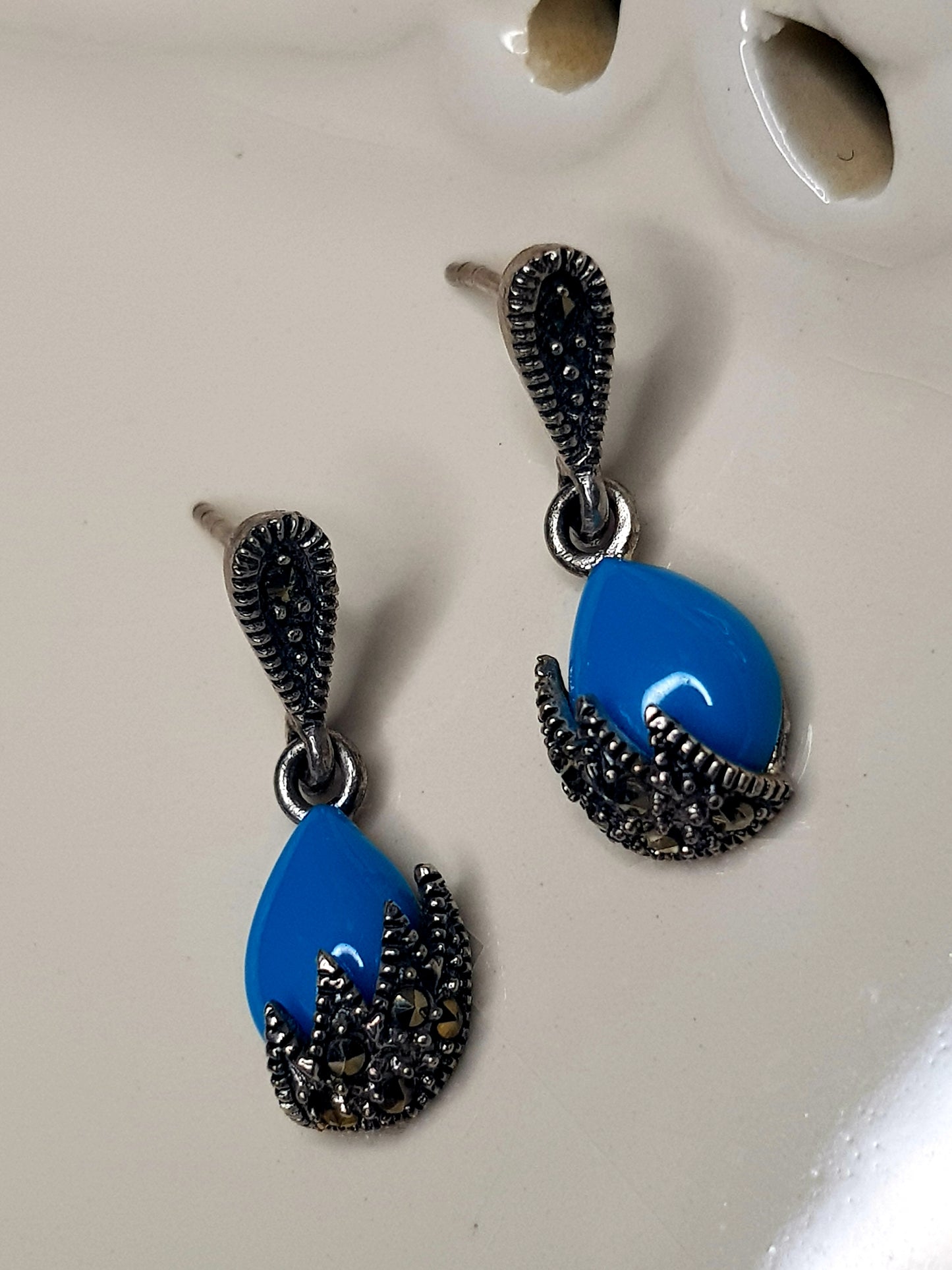 Silver earrings, teardrop shaped turquoise stone hanging under silver stud, marcasite detailing