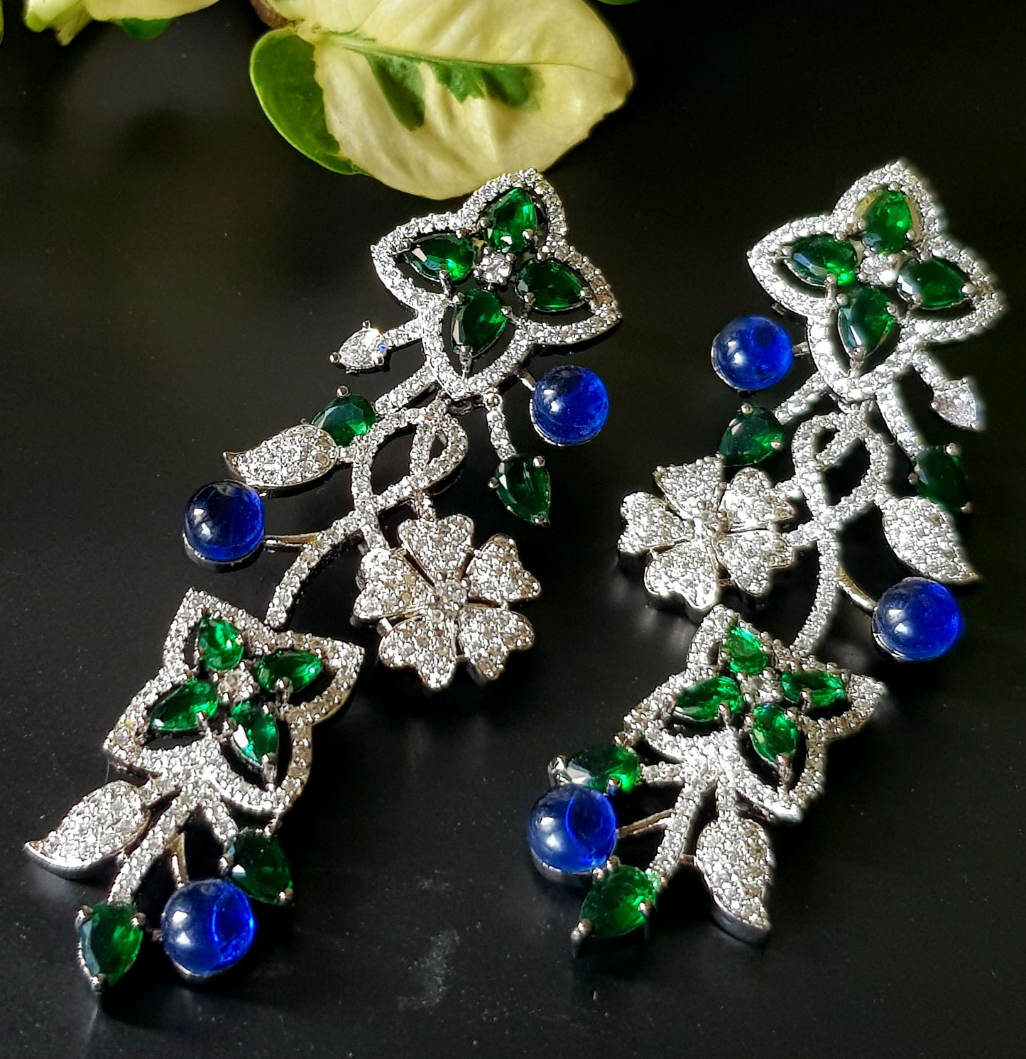 Platinum finish long studs (earrings), floral design in pale pink/sapphire and emerald stone detailing