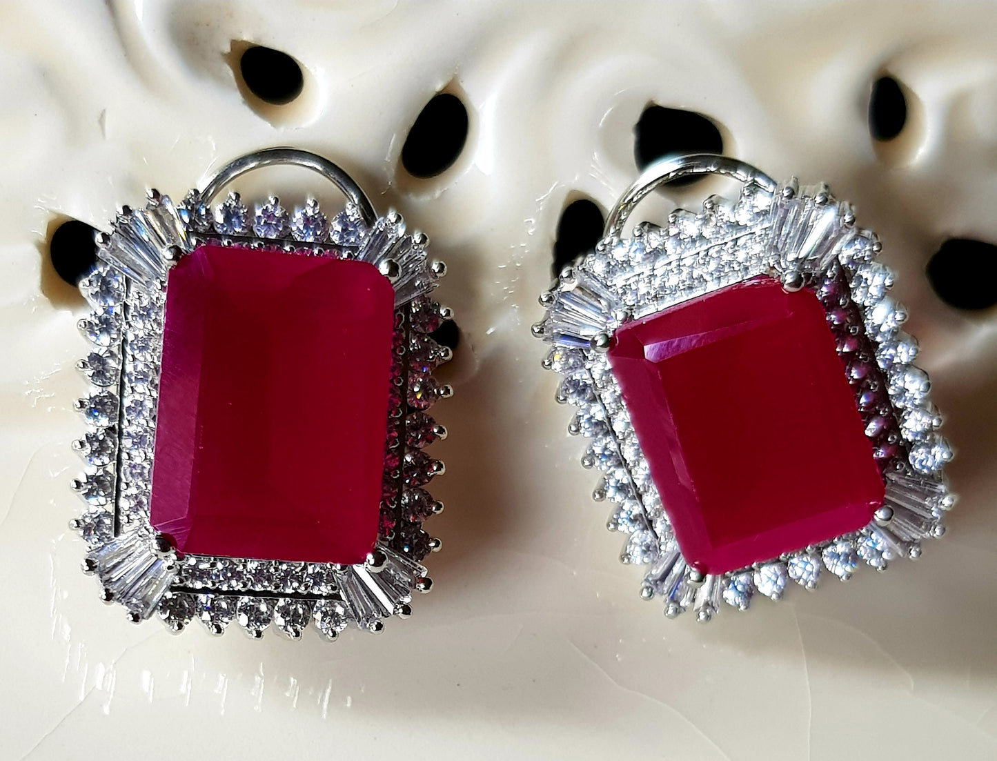 Platinum finish studs (earrings), big ruby stone in the center with CZ detailing