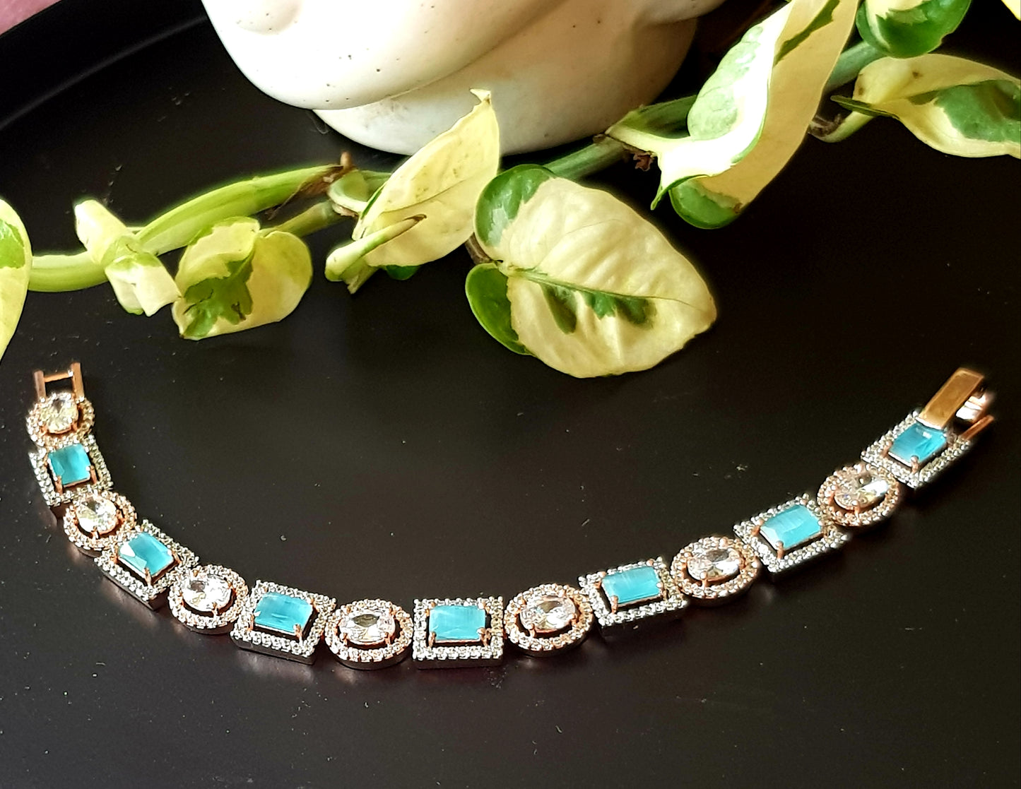 Platinum finish bracelet, square aqua/topaz stone surrounded by CZ interspaced with oval clear stone with CZ around