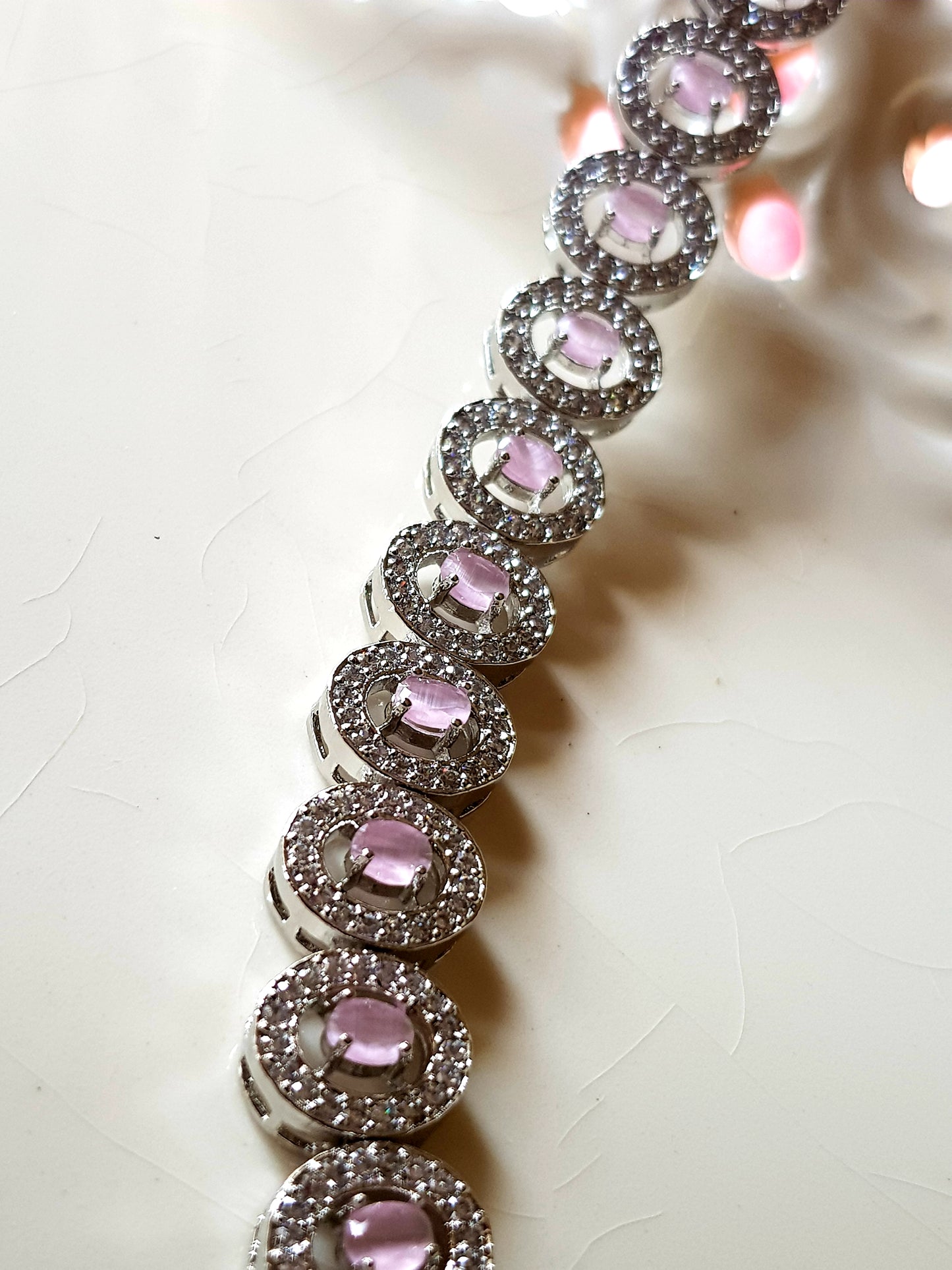 Platinum finish bracelet, oval shaped pale pink stone with CZ setting around