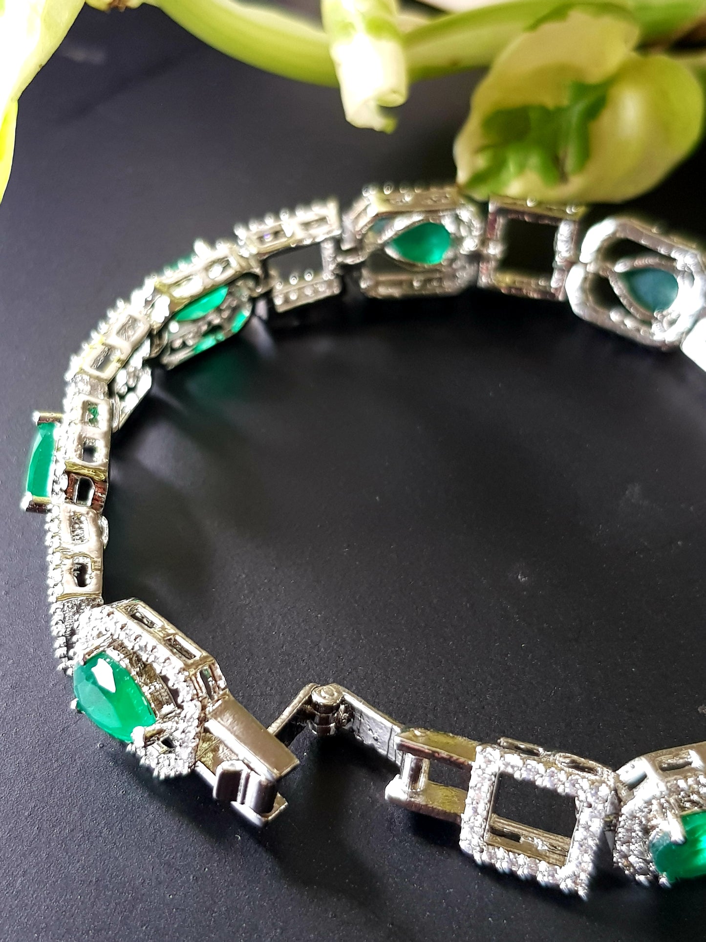 Platinum finish bracelet with teardrop emeralds framed with CZ