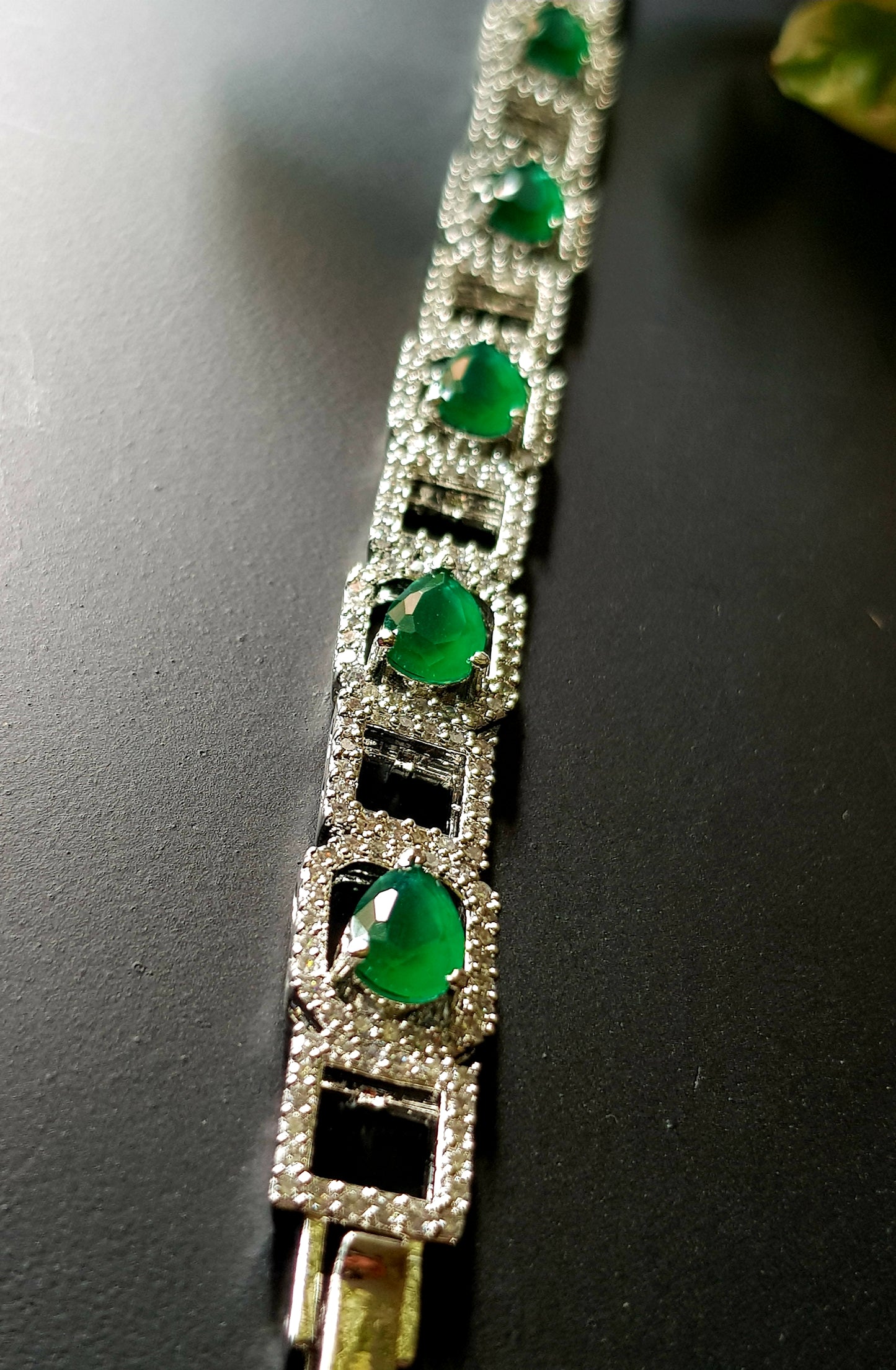 Platinum finish bracelet with teardrop emeralds framed with CZ