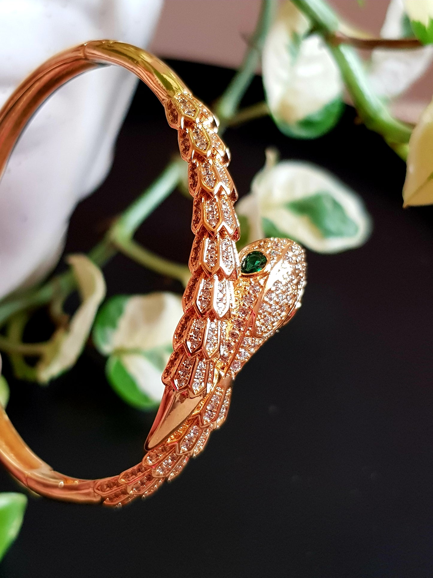 Snake shaped gold finish bracelet with emerald stone eye, embellished with CZ