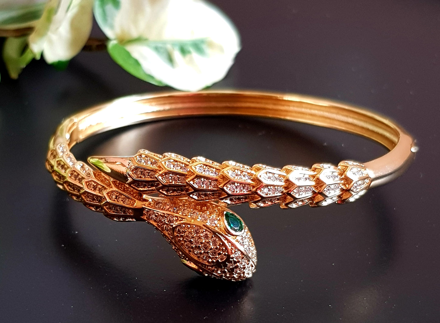 Snake shaped gold finish bracelet with emerald stone eye, embellished with CZ