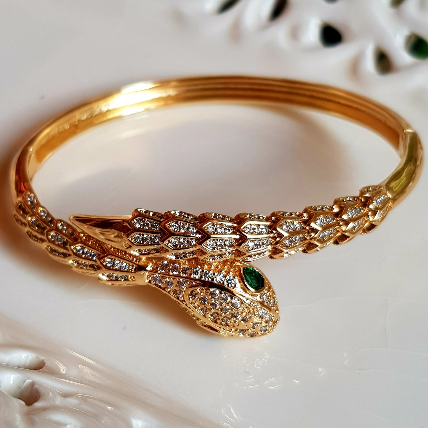 Snake shaped gold finish bracelet with emerald stone eye, embellished with CZ