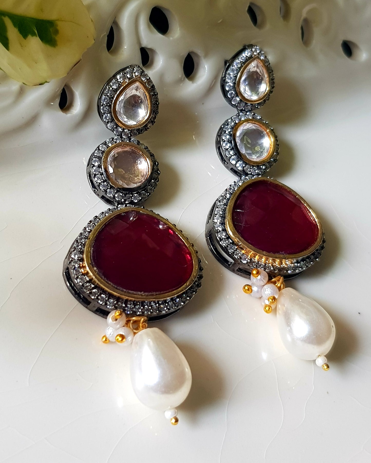 Antique silver finish earrings with ruby red/green stone on kundan hangings surrounded by CZ