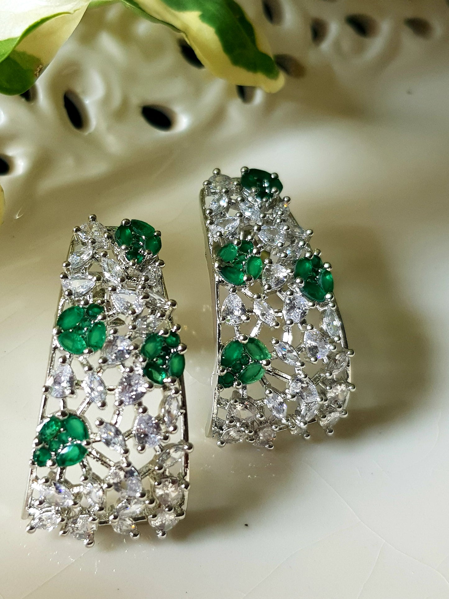 Platinum finish with CZ and emerald, jaali design big studs (earrings)