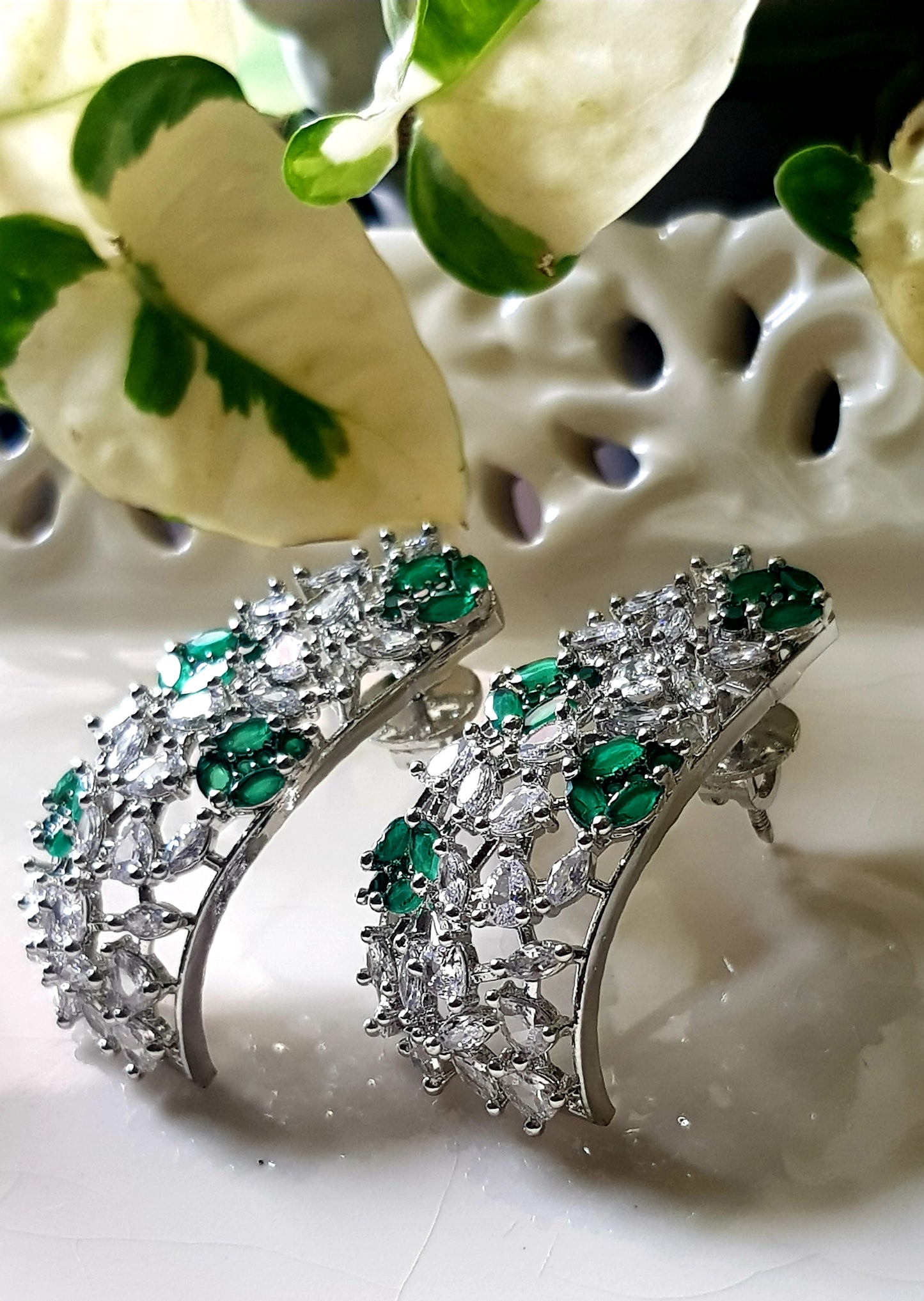 Platinum finish with CZ and emerald, jaali design big studs (earrings)