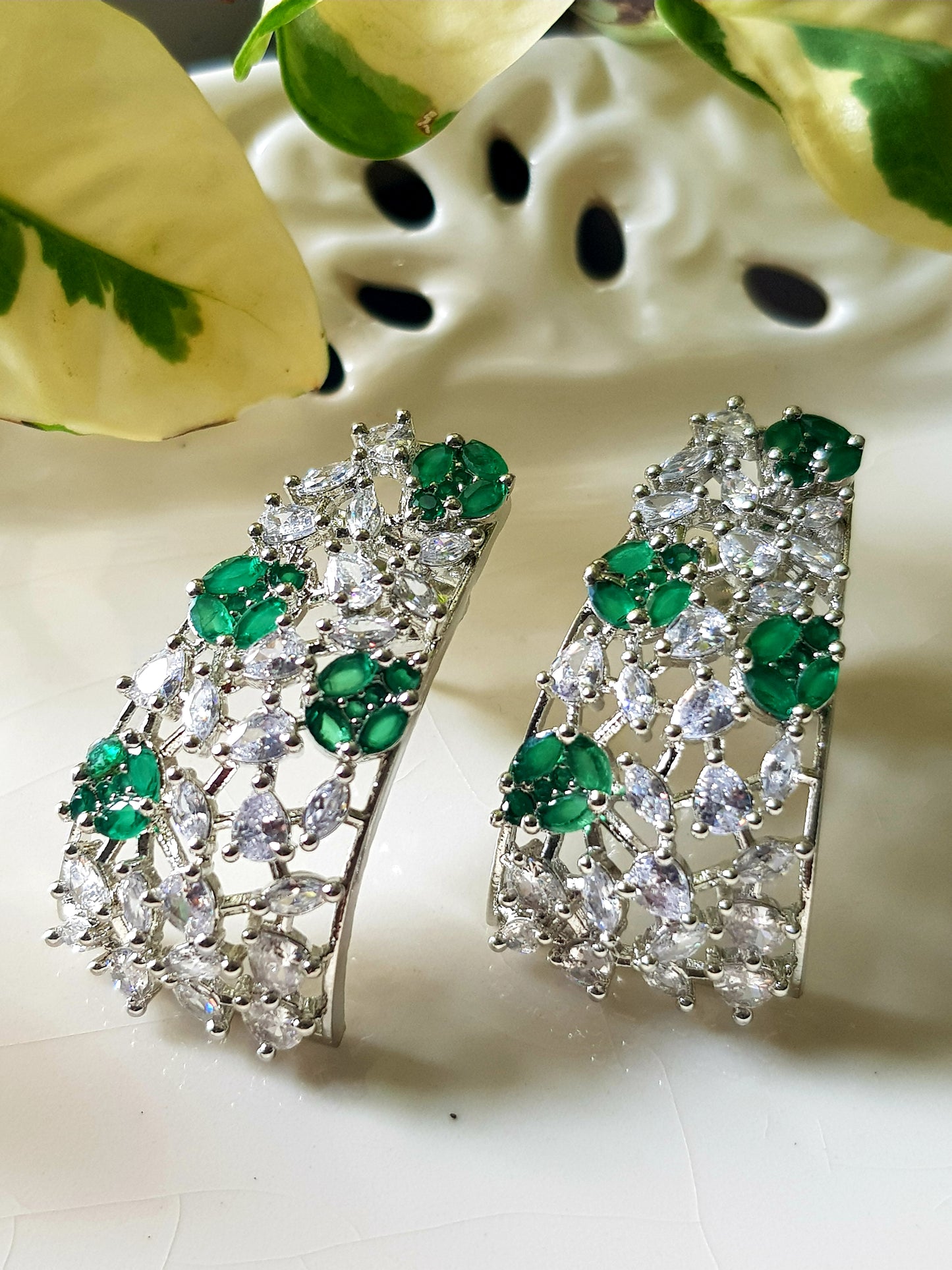 Platinum finish with CZ and emerald, jaali design big studs (earrings)