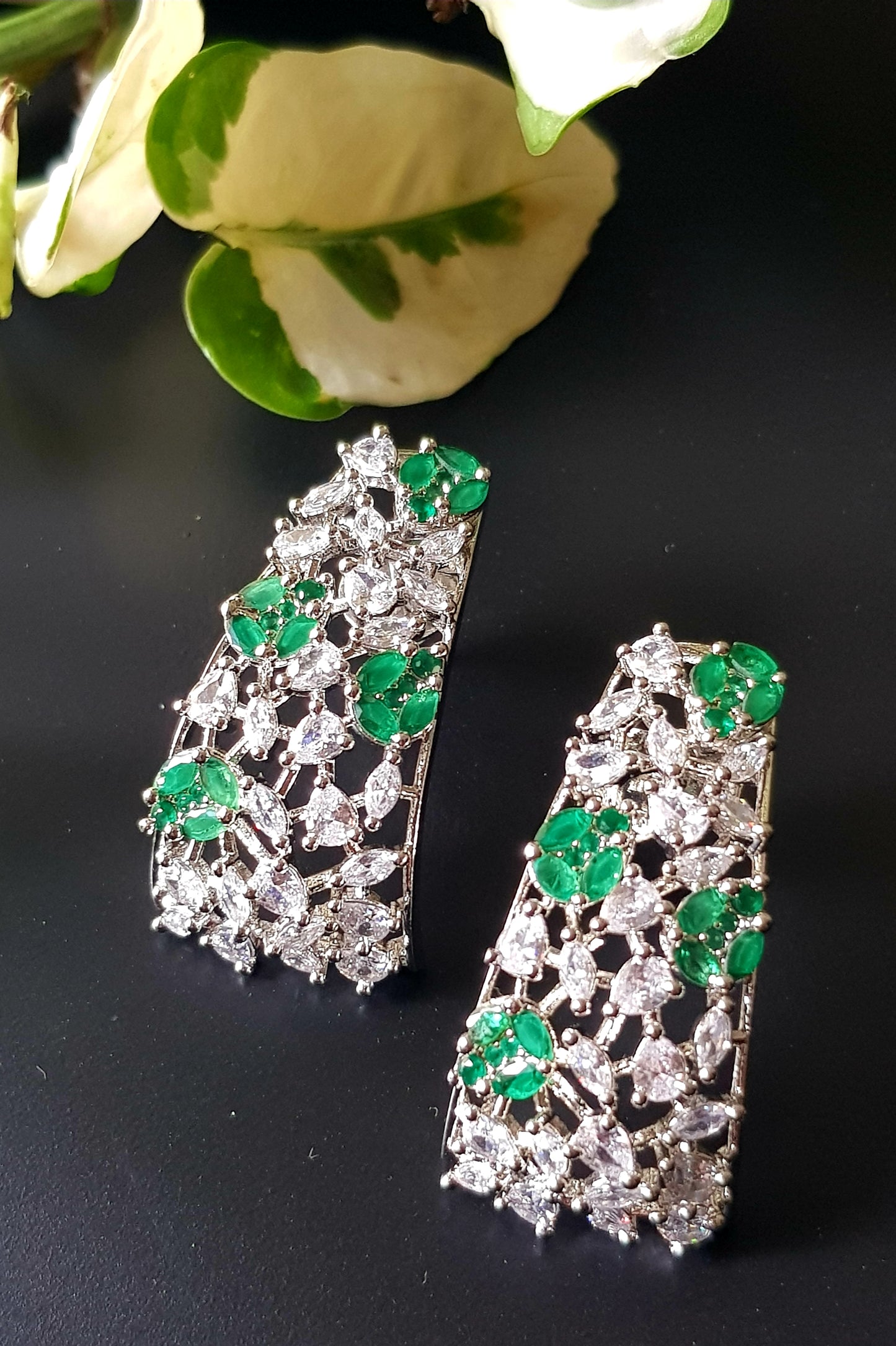 Platinum finish with CZ and emerald, jaali design big studs (earrings)