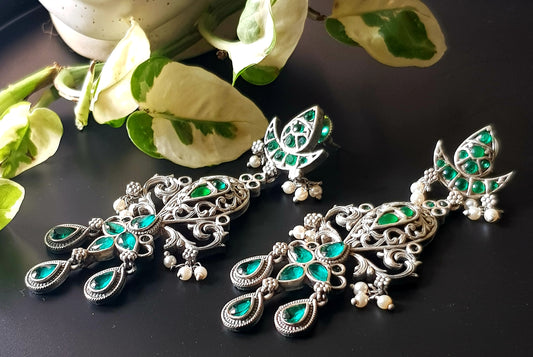 Silver finish long earrings with emerald stone detailing