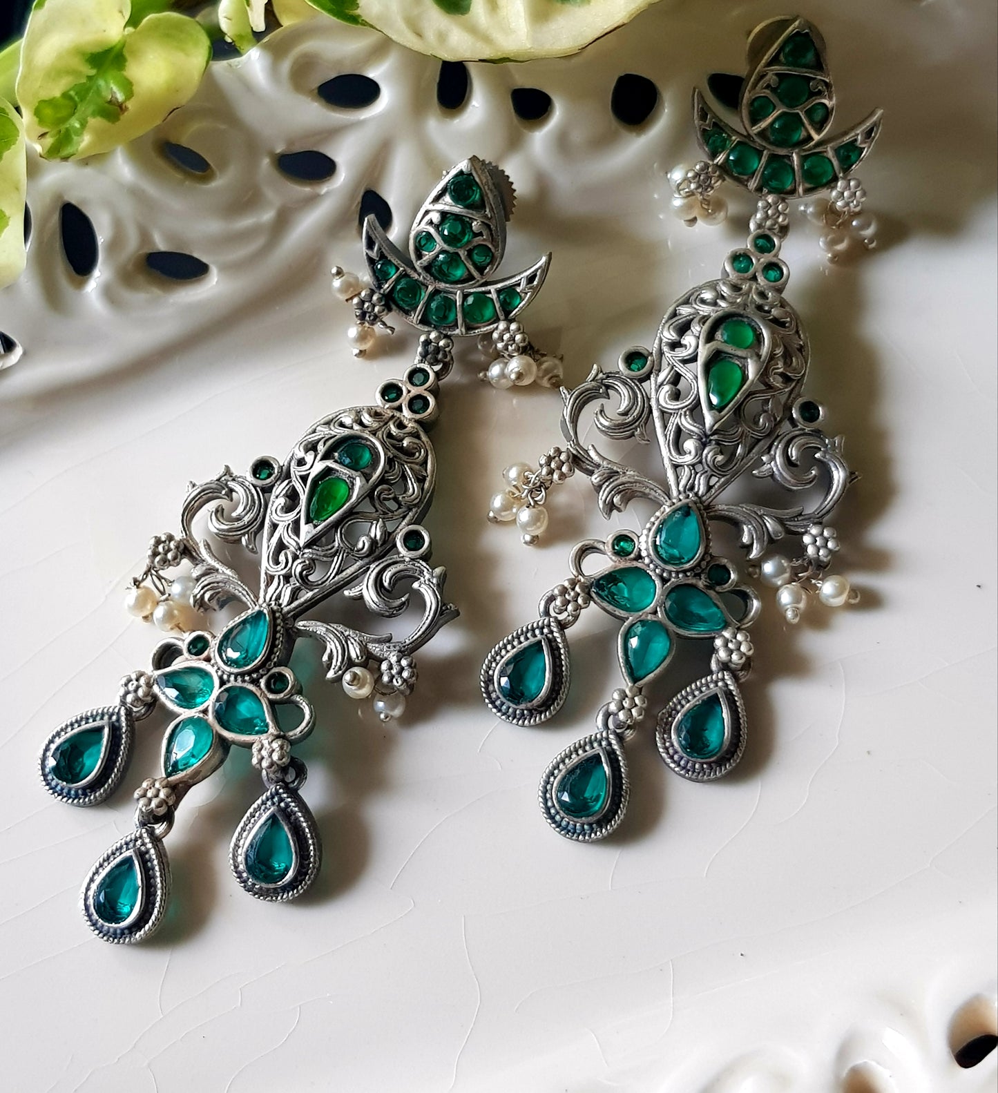 Silver finish long earrings with emerald stone detailing