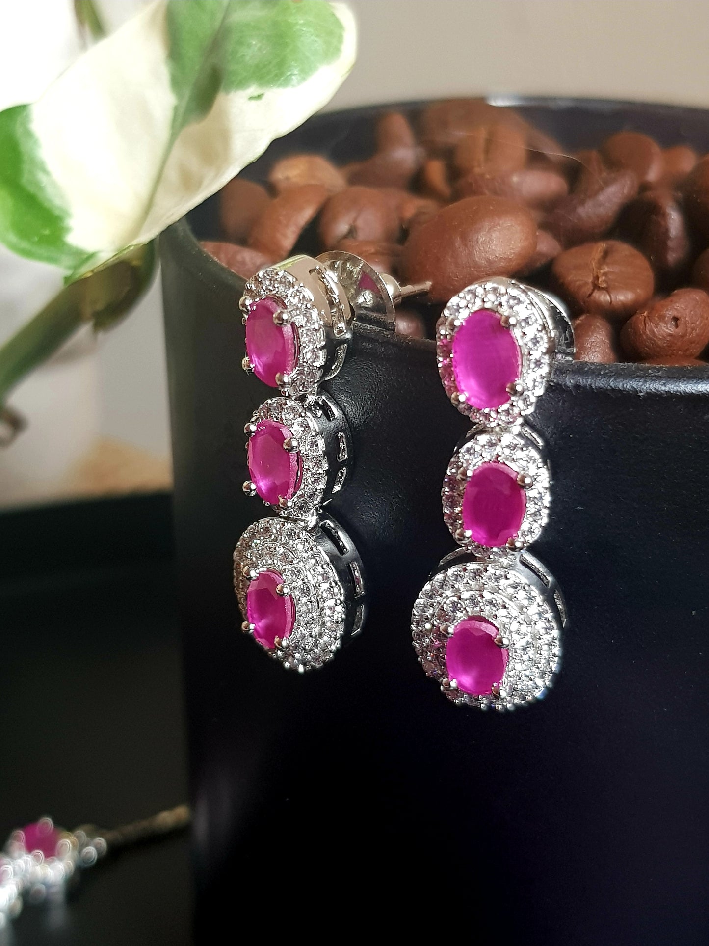 Platinum finish set in oval shaped ruby stone surrounded by CZ and matching pendant, matching earrings