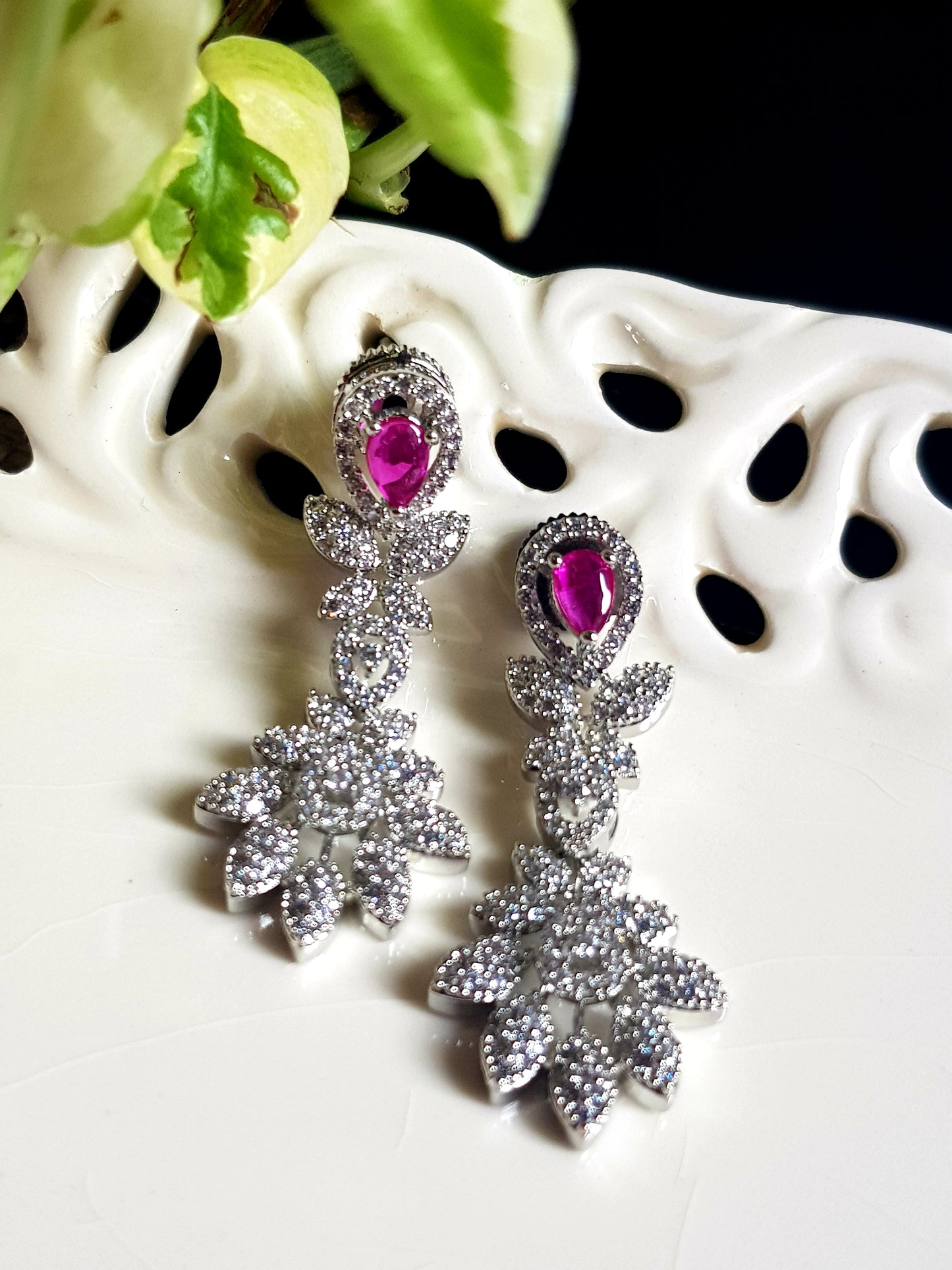 Platinum finish single strand set in leaf inspired CZ design and teardrop shaped ruby/emerald stone pendant, matching earrings