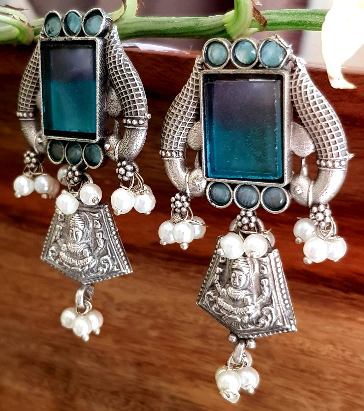 Antique silver finish earrings, peacock and Lakshmi motif around dual shaded square stone and pearl beads