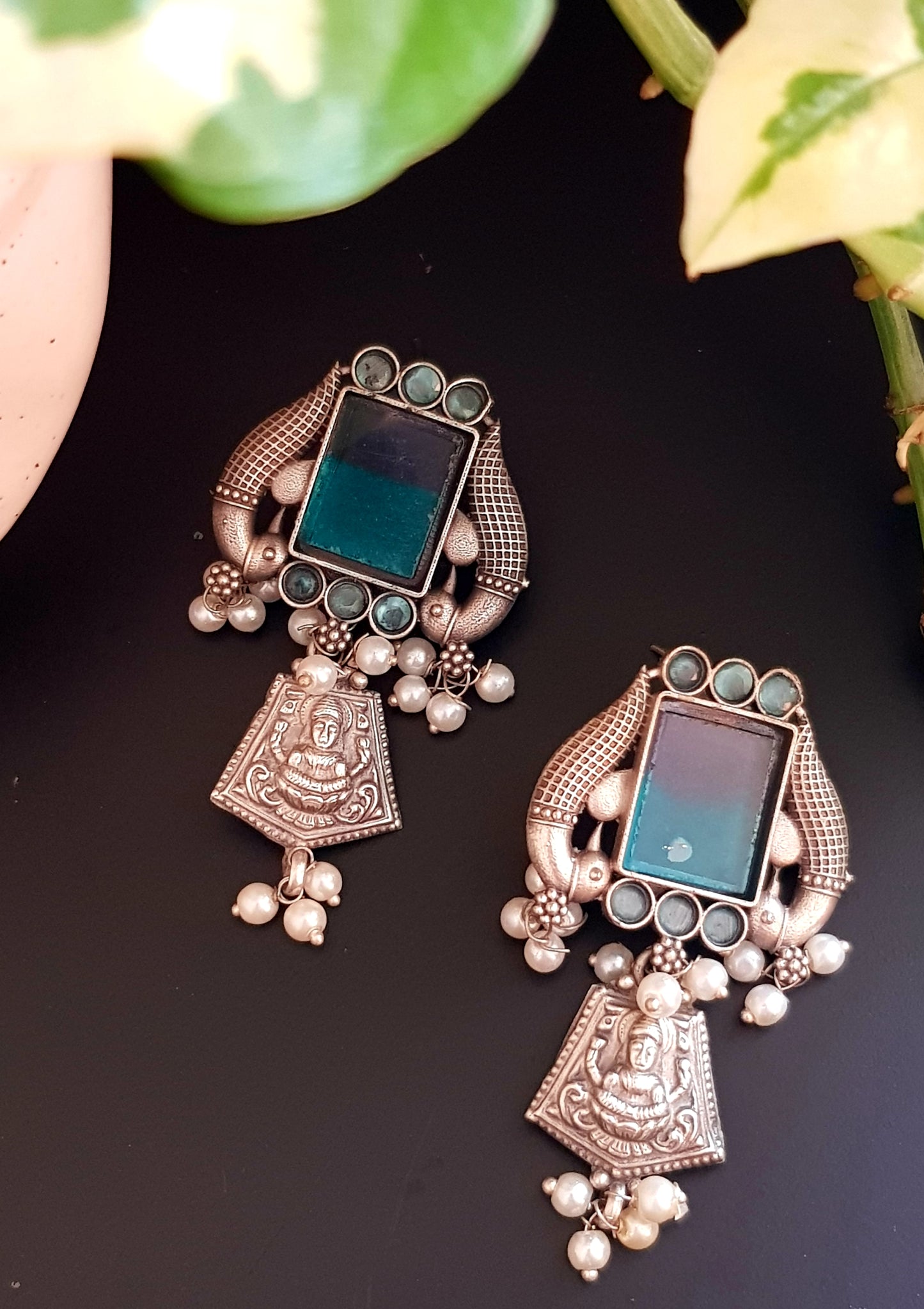 Antique silver finish earrings, peacock and Lakshmi motif around dual shaded square stone and pearl beads