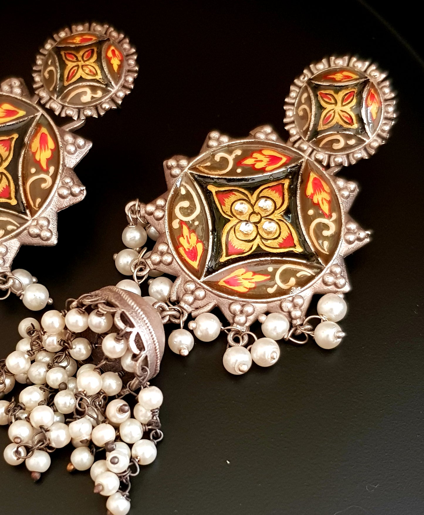 Silver finish long jhumka (earrings) with handpainted sun shaped pieces and pearl trailings