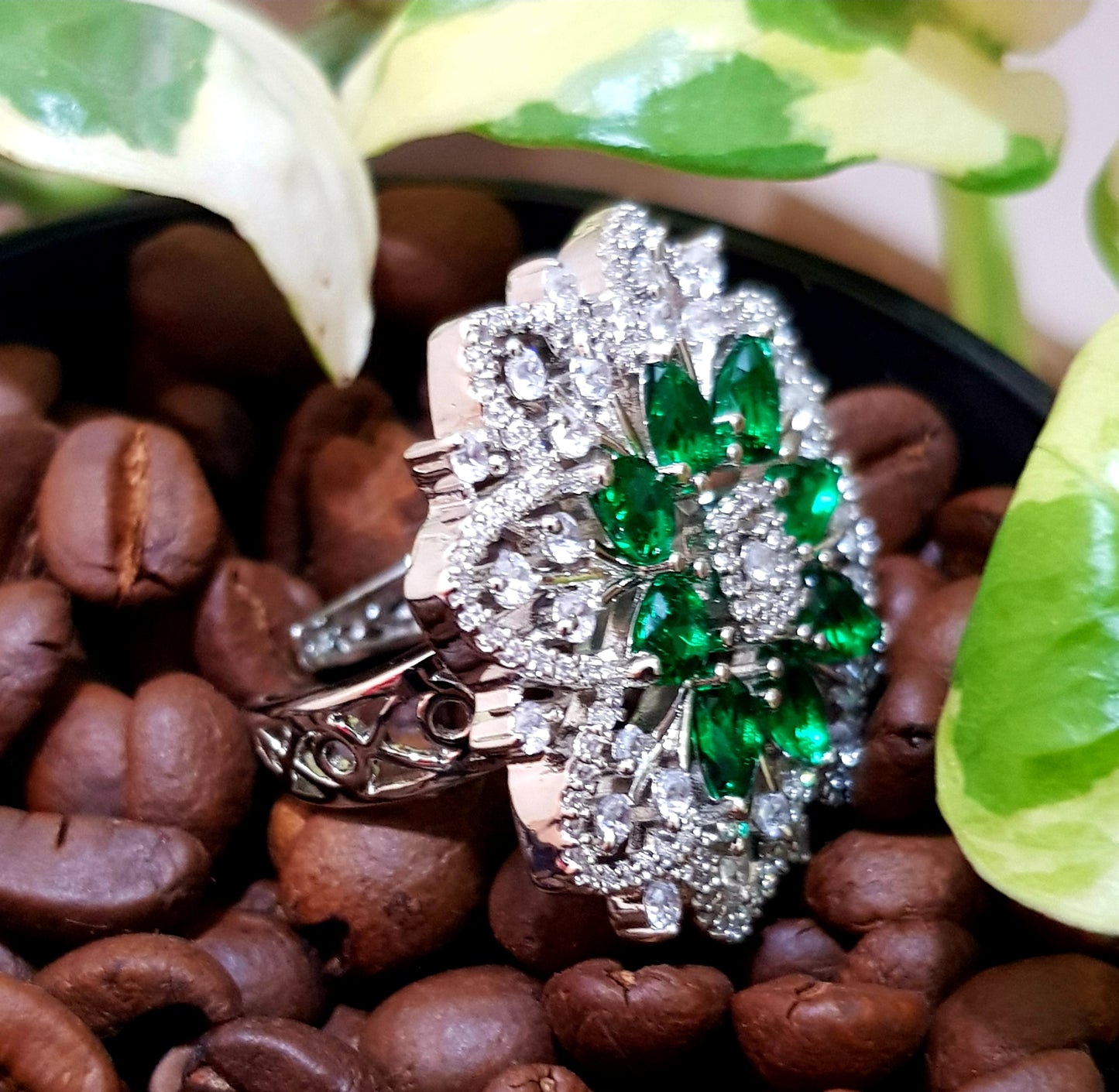 Platinum finish ring with emerald flower and CZ detailing all over