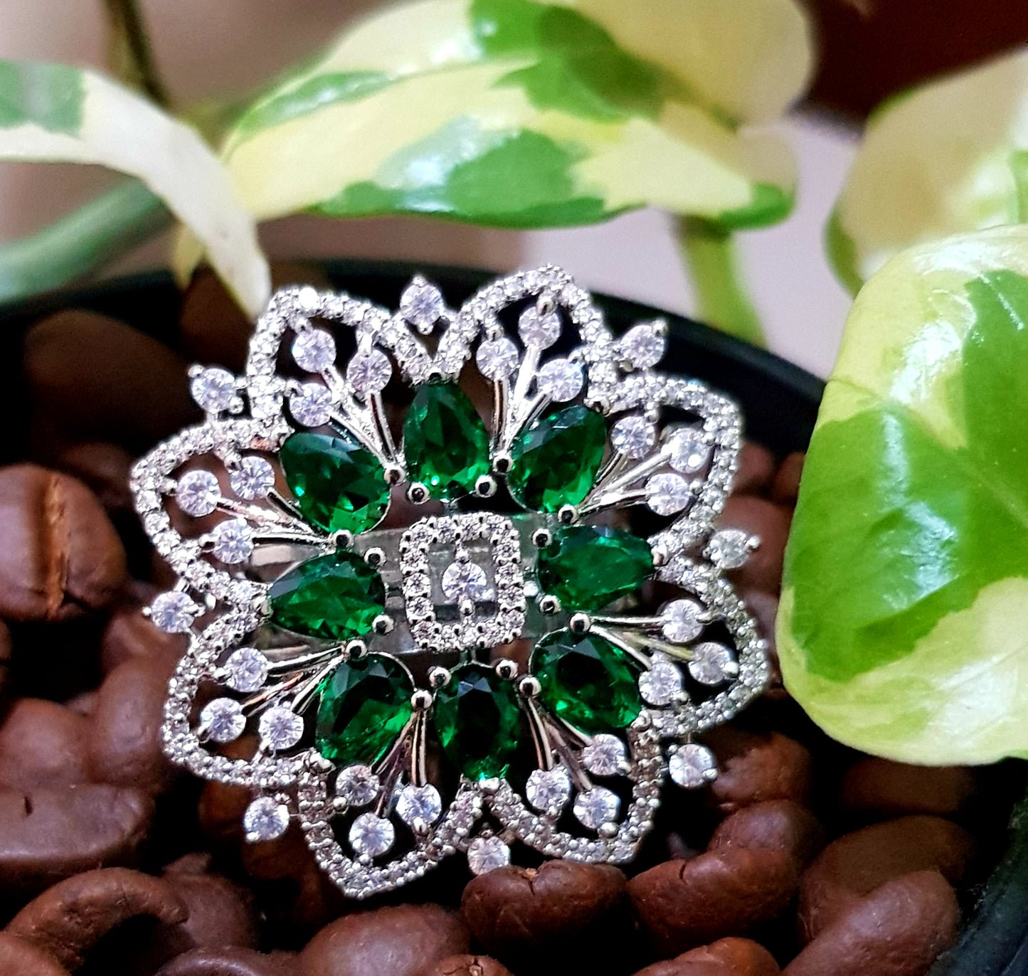 Platinum finish ring with emerald flower and CZ detailing all over