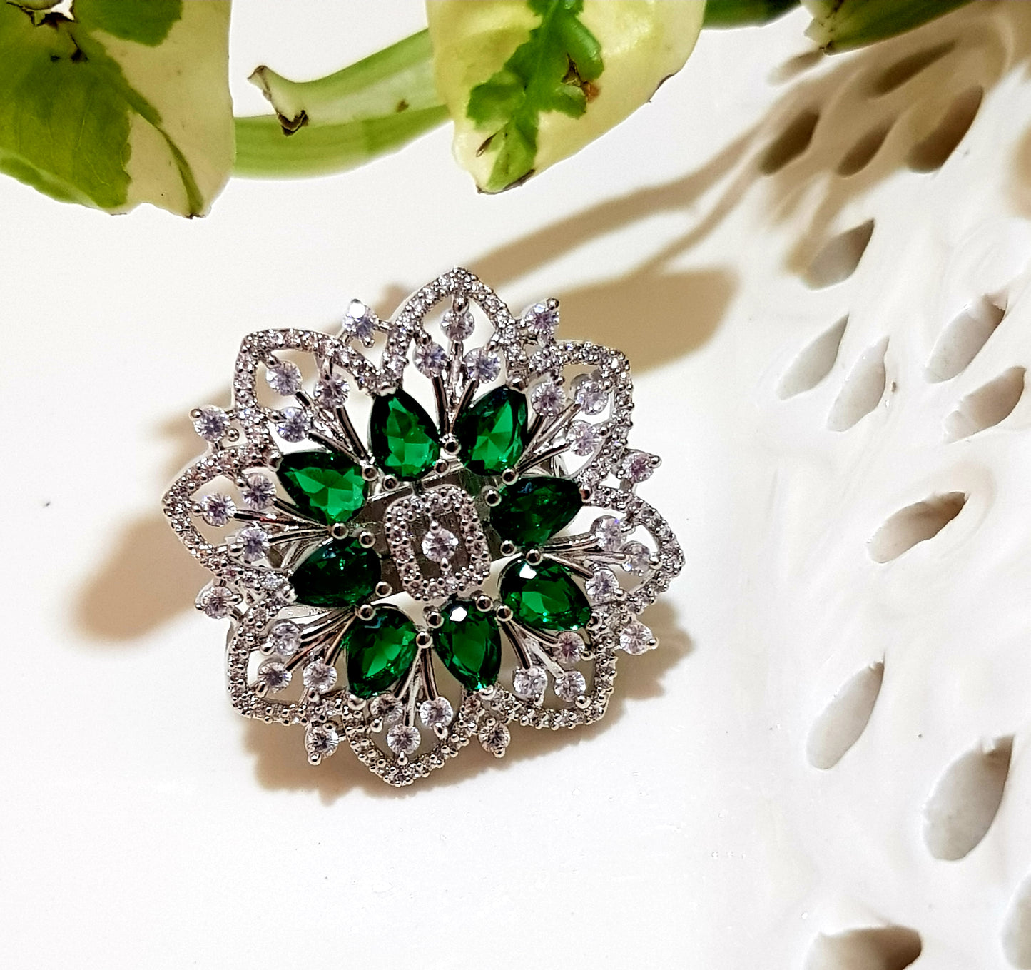 Platinum finish ring with emerald flower and CZ detailing all over