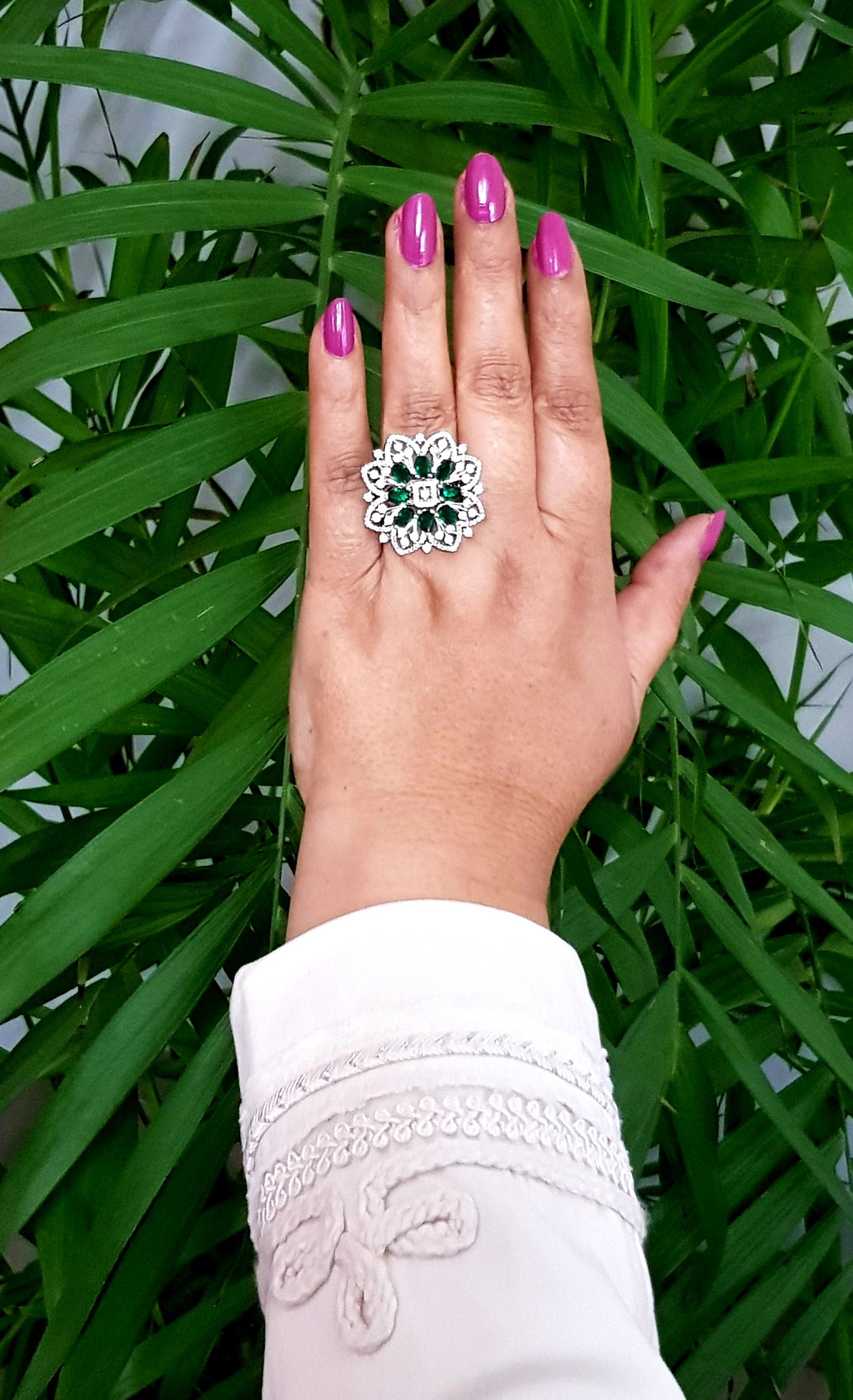 Platinum finish ring with emerald flower and CZ detailing all over