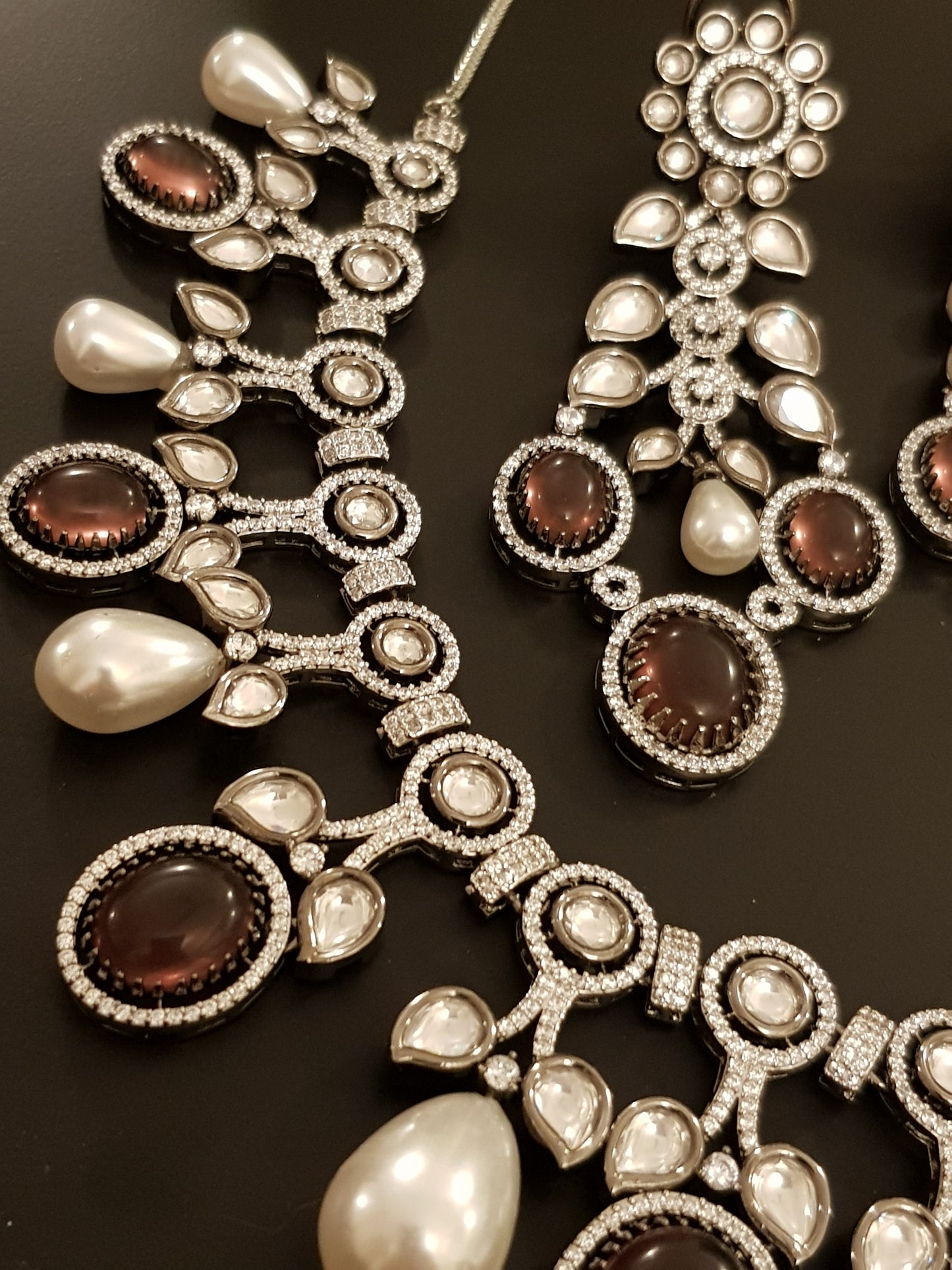 Platinum finish set with plum coloured stone, kundan, pearl and CZ necklace, matching earrings