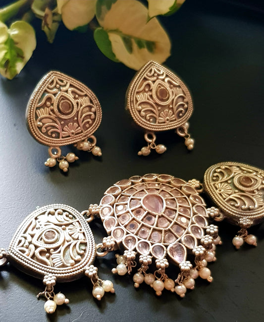 Silver finish set, betel leaf shaped tikdas with pale pink/pale green stone detailing in choker, matching earrings