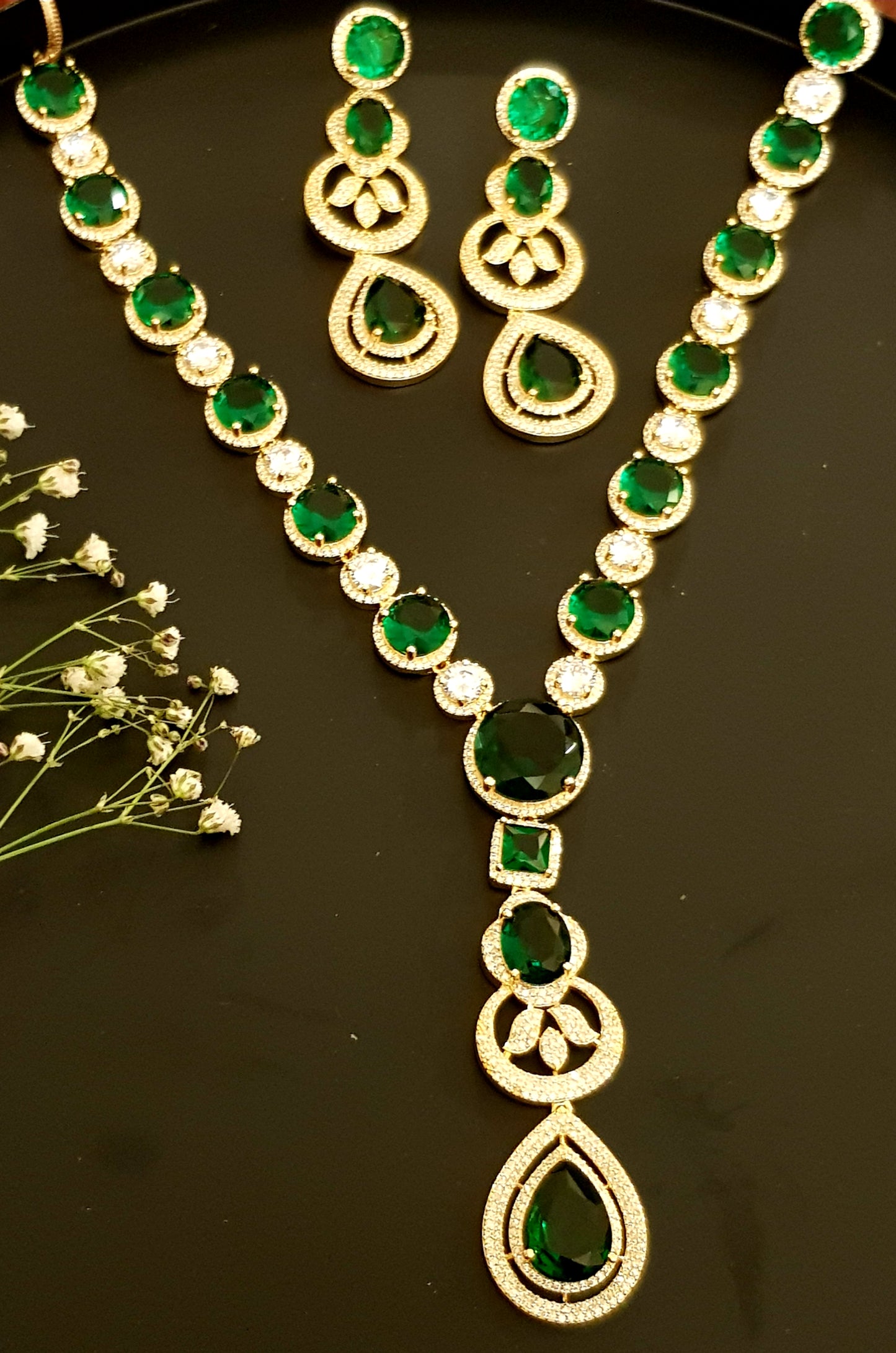 Gold finish set with long necklace in round CZ and emerald pieces, matching earrings