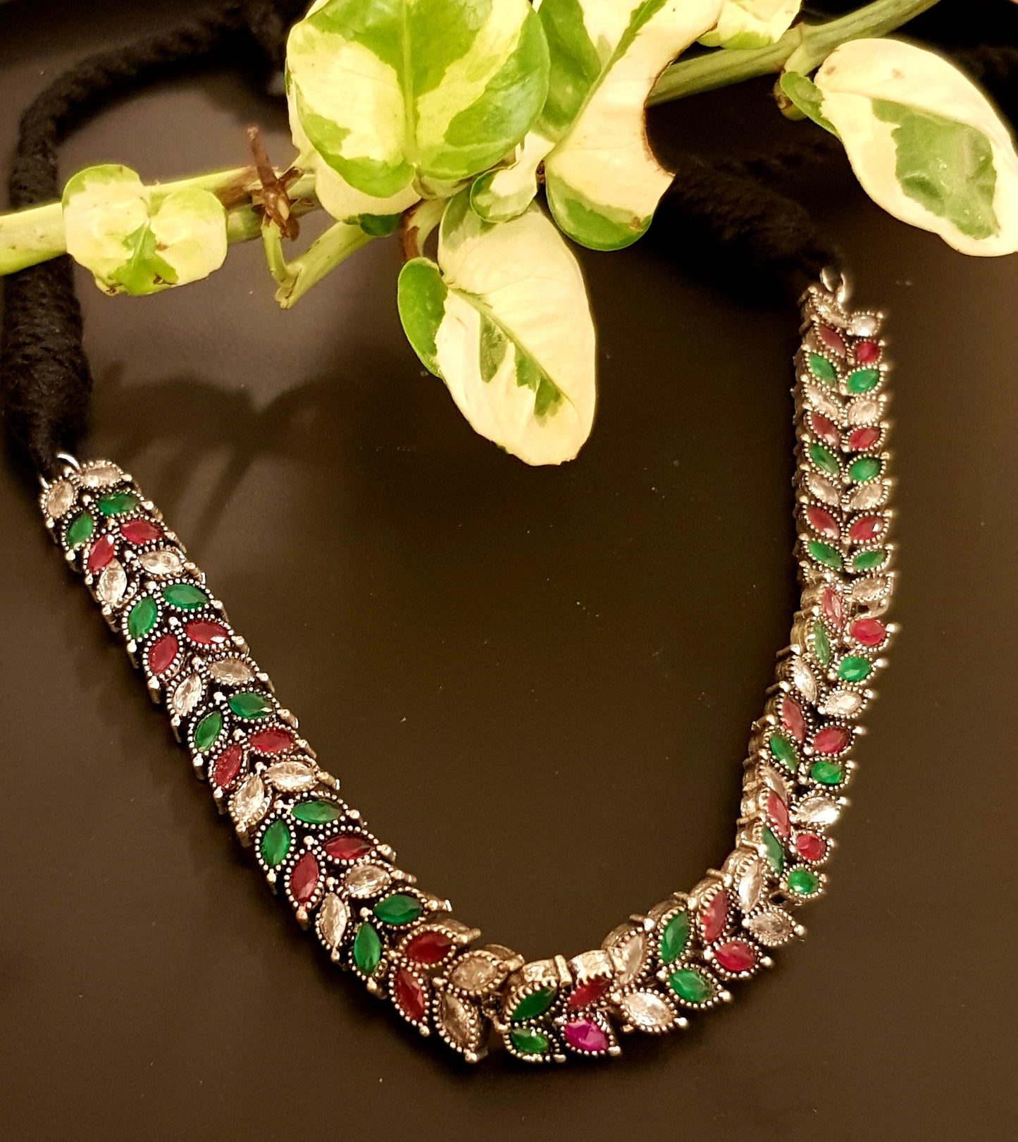 Silver finish sleek choker with red,green and clear stone leaf design