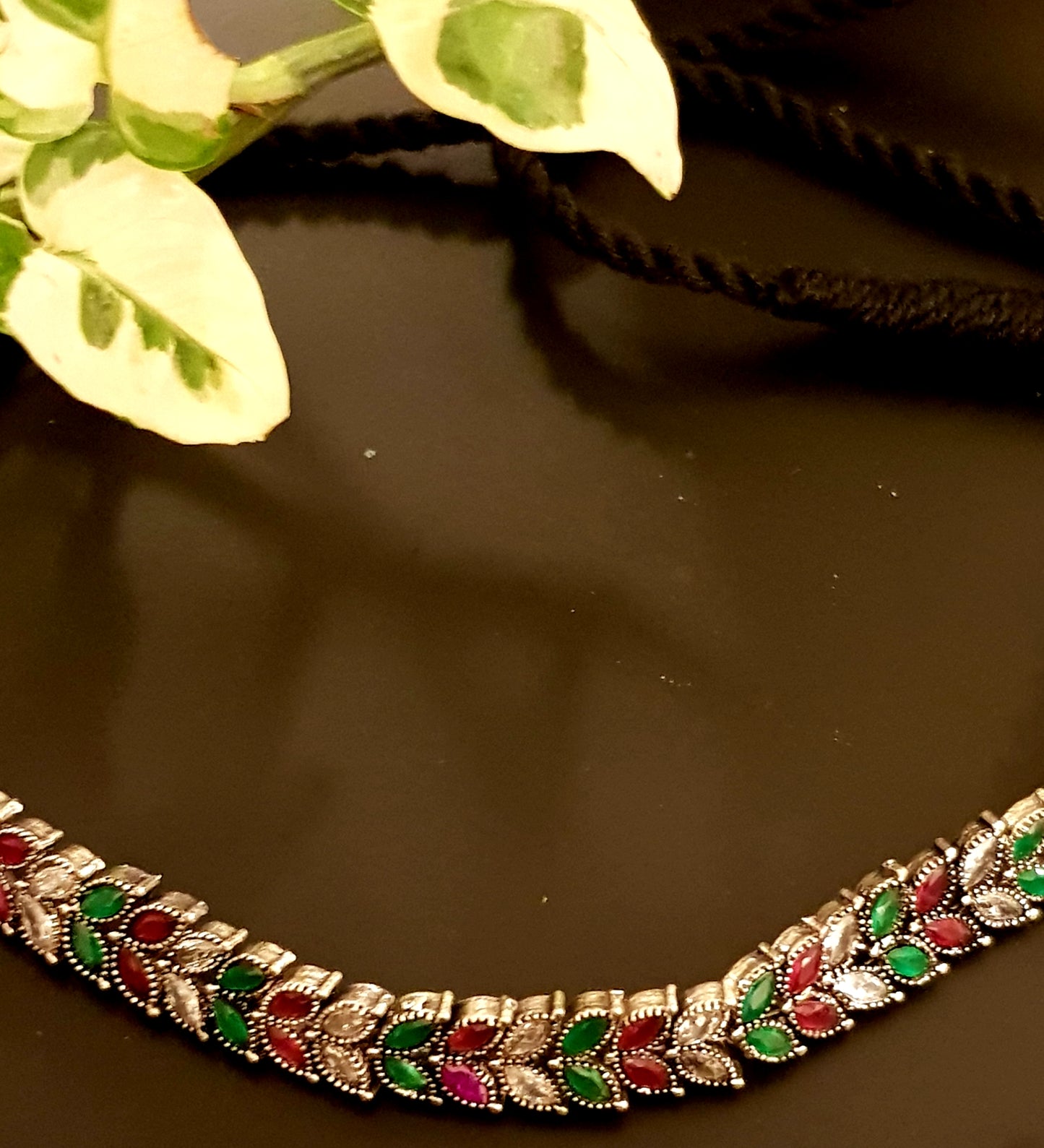 Silver finish sleek choker with red,green and clear stone leaf design